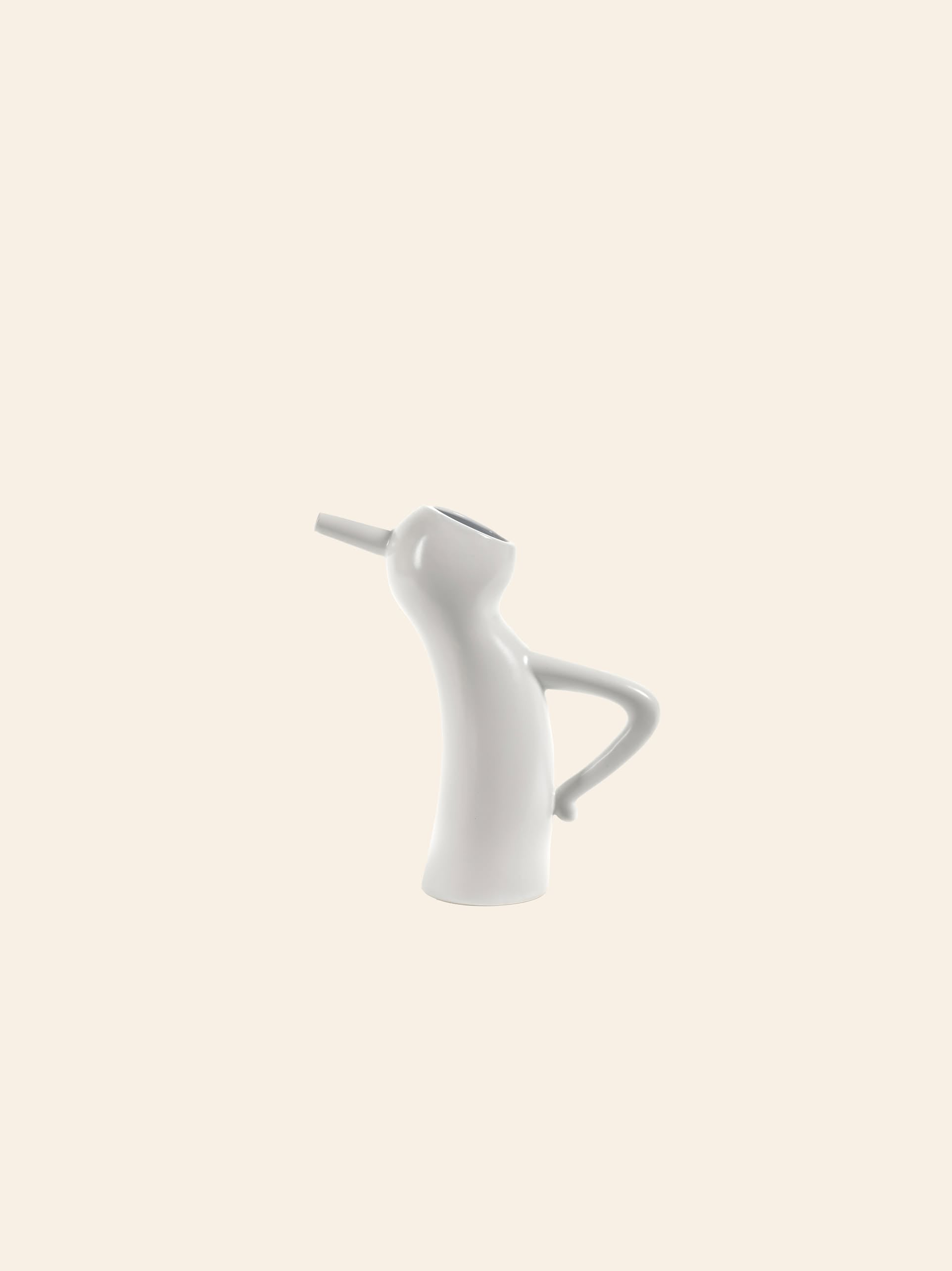 The Serax Monsieur Cruchot Jug S in white features a modern, abstract ceramic design with a curved body, narrow spout, and handle like an arm, by Serax. Shown against a plain beige background.