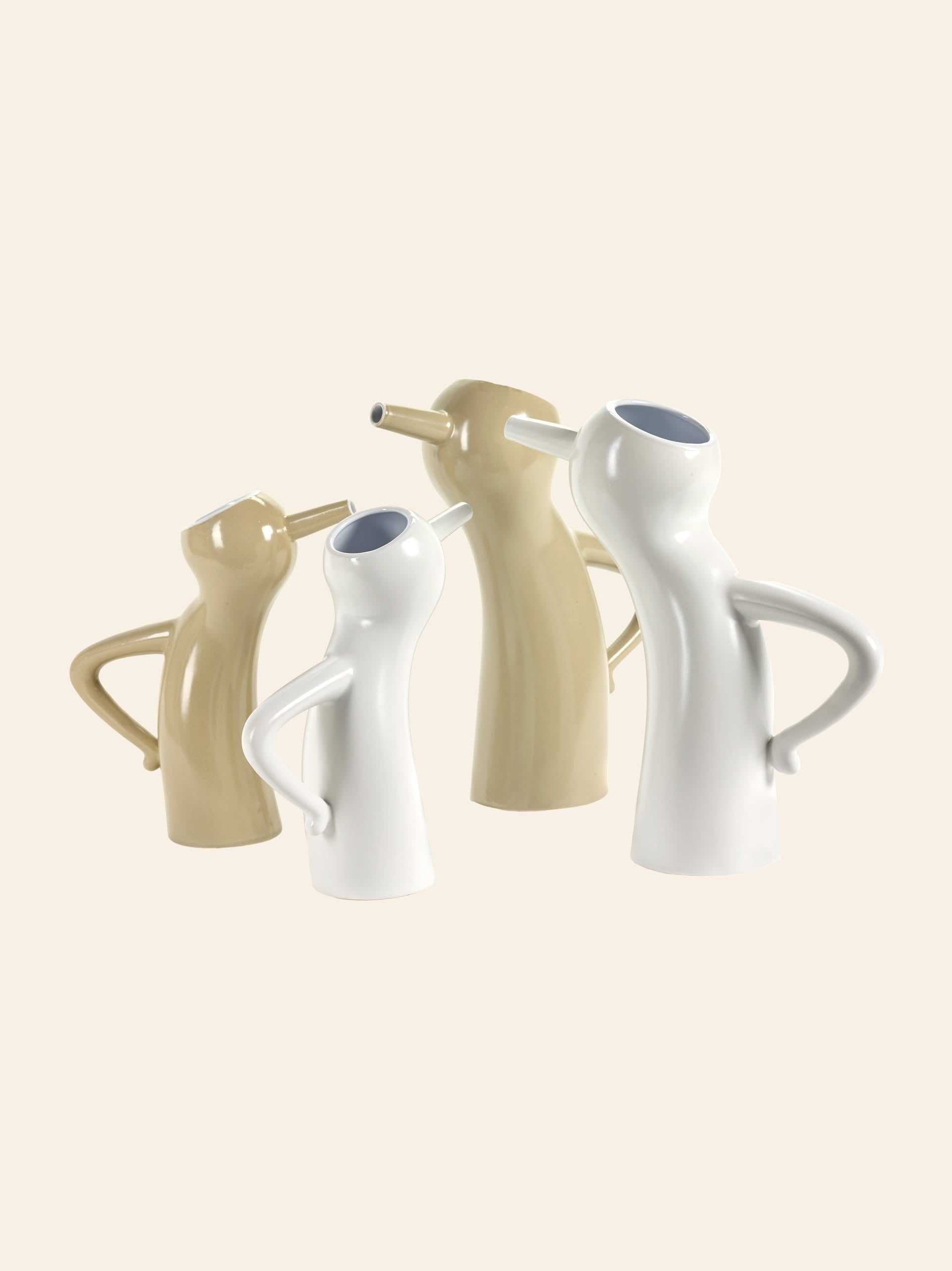 Four Serax Monsieur Cruchot Jug S - White, modern and sculptural with curved bodies, side handles, and angled spouts, are arranged upright against a light beige background.