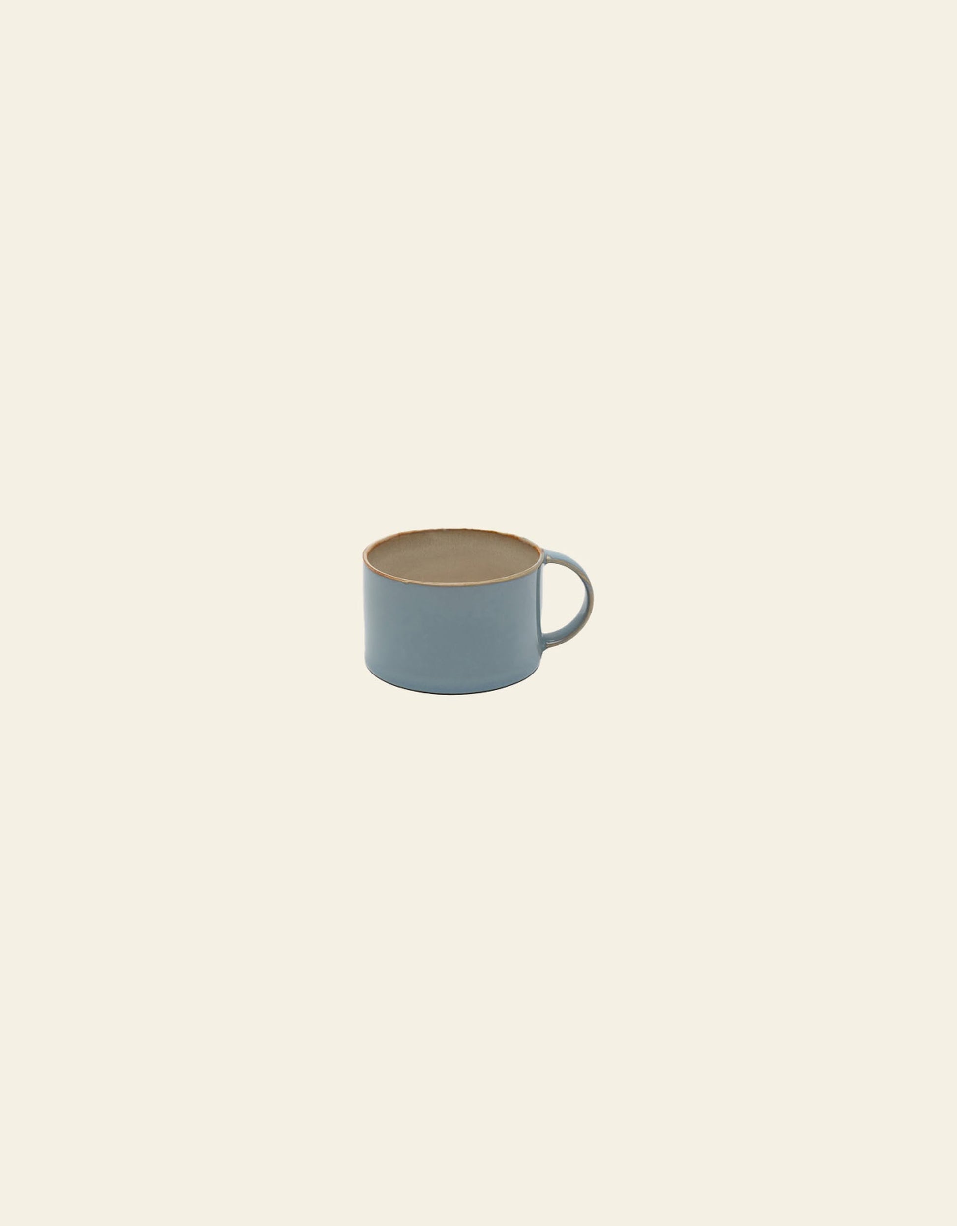 The Serax Terres De Rêves Coffee Cup by Serax is a handcrafted, light blue ceramic mug with a round handle, beige rim, and minimalist design, shown centered on a plain off-white background.