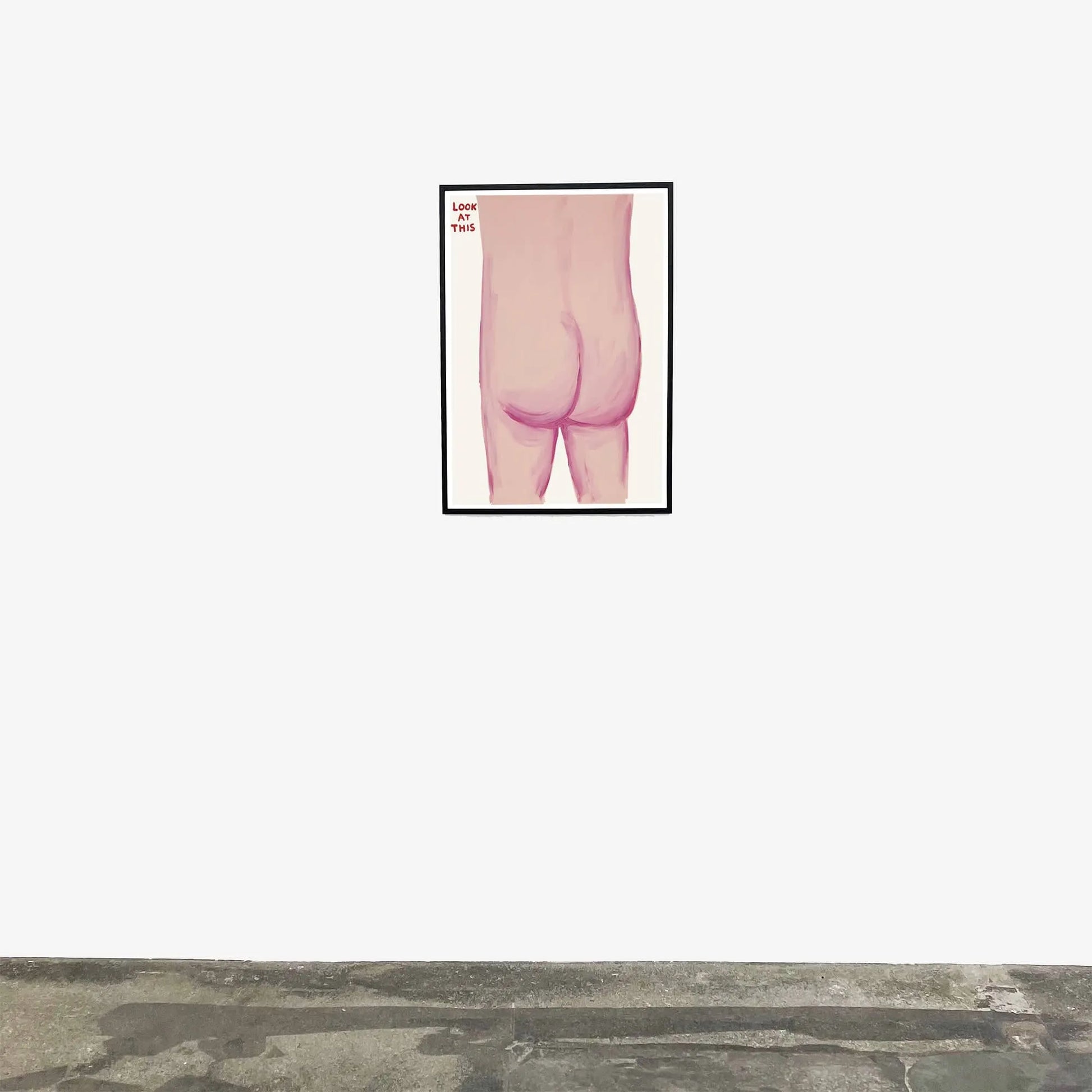 The Shrig Shop David Shrigley - Look At This (60x80) features a nude figure in pink tones with Love This written in red at the top left, displayed framed on a white wall above a concrete floor.
