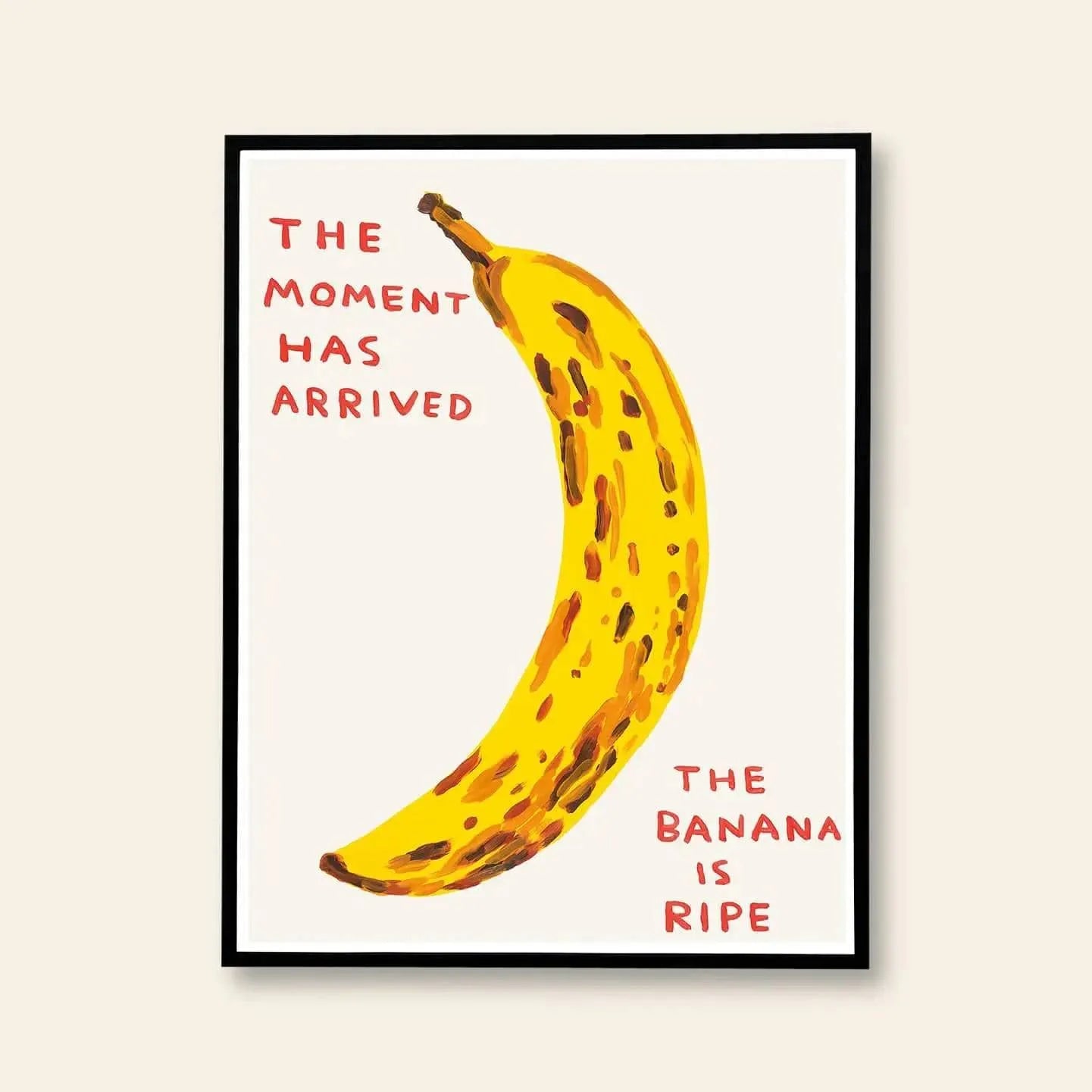 The Shrig Shop David Shrigley - The Moment Has Arrived (60x80) is a framed illustration with a spotted banana and bold red text—THE MOMENT HAS ARRIVED and THE BANANA IS RIPE—set against a cream background.