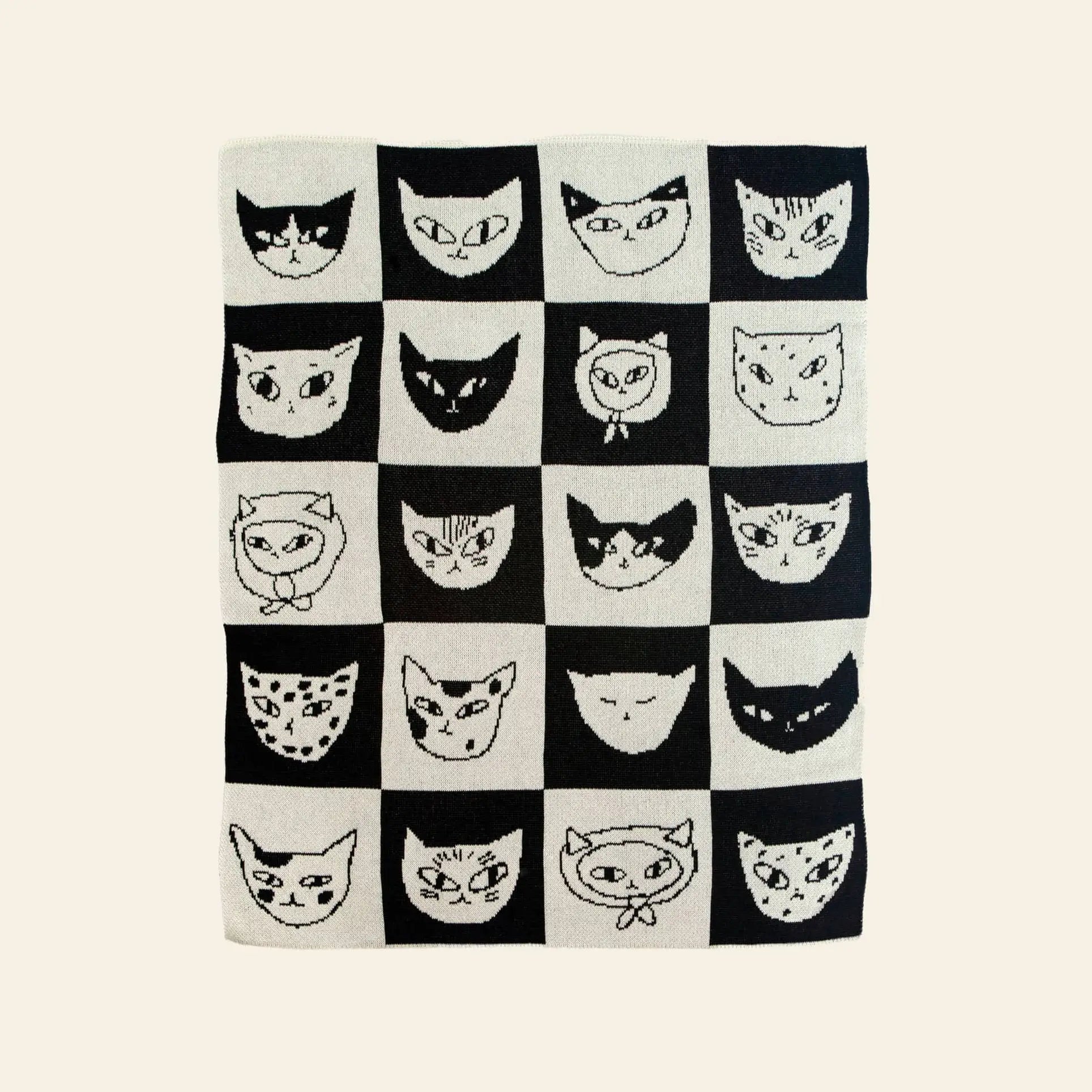 The Slowdown Studio Cat Bingo Mini Blanket showcases a black and white checkered grid with unique hand-drawn cat faces. Made from a recycled cotton blend, it brings playful, eco-friendly charm to any space.