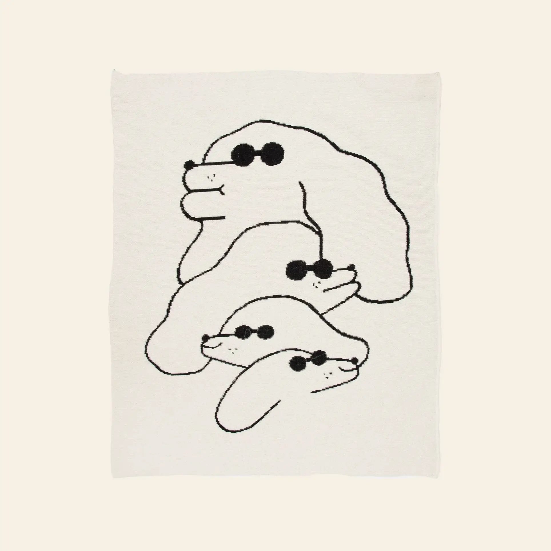 The Slowdown Studio Dawgs Mini Blanket features a minimalist illustration of three stacked dogs in sunglasses, drawn in black lines on white, inspired by Slowdown Studio. Made from recycled cotton.