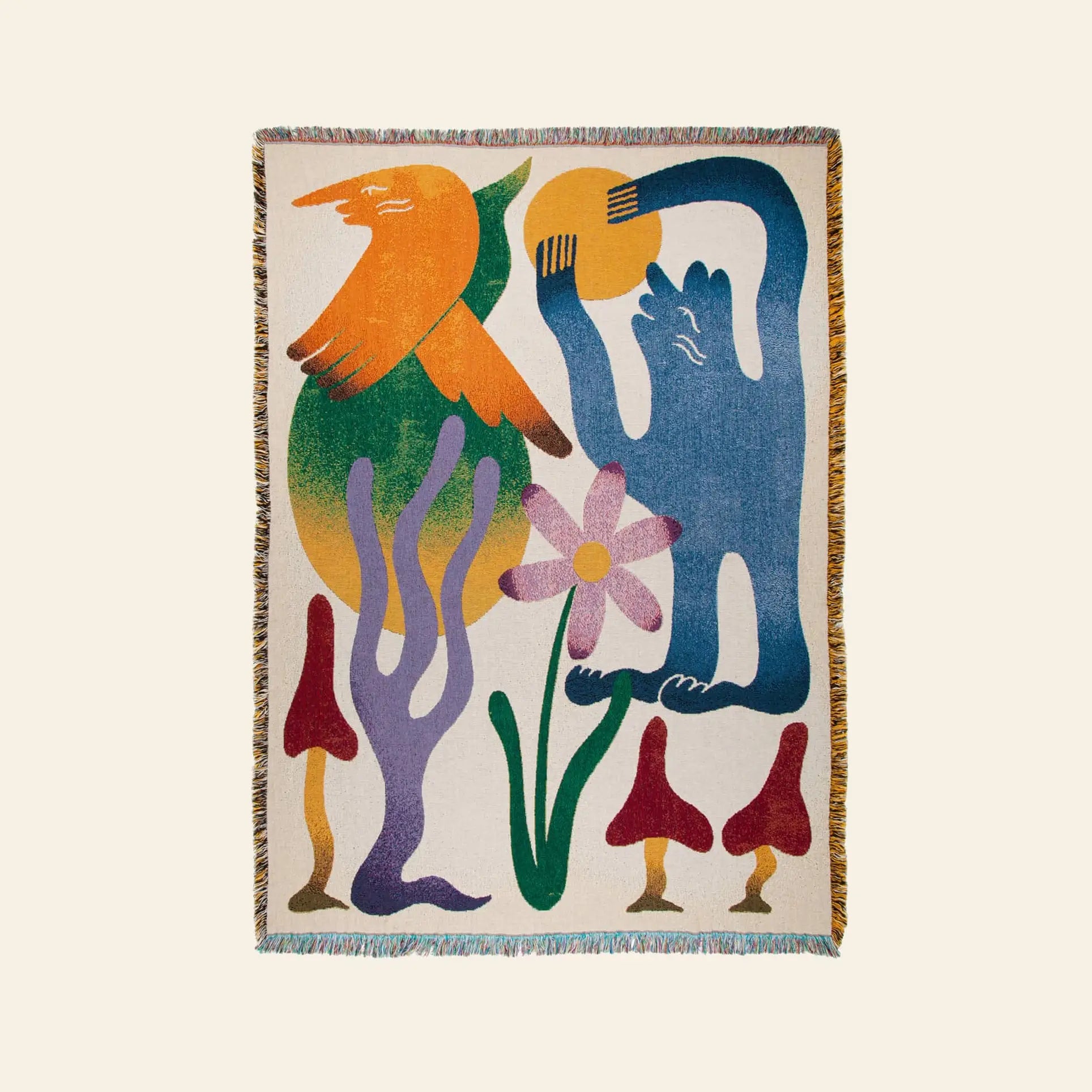 The Slowdown Studio Dumont Throw features abstract shapes—a bright bird, blue figure, pink flower, and red mushrooms—woven from recycled cotton with fringed edges on a light background.