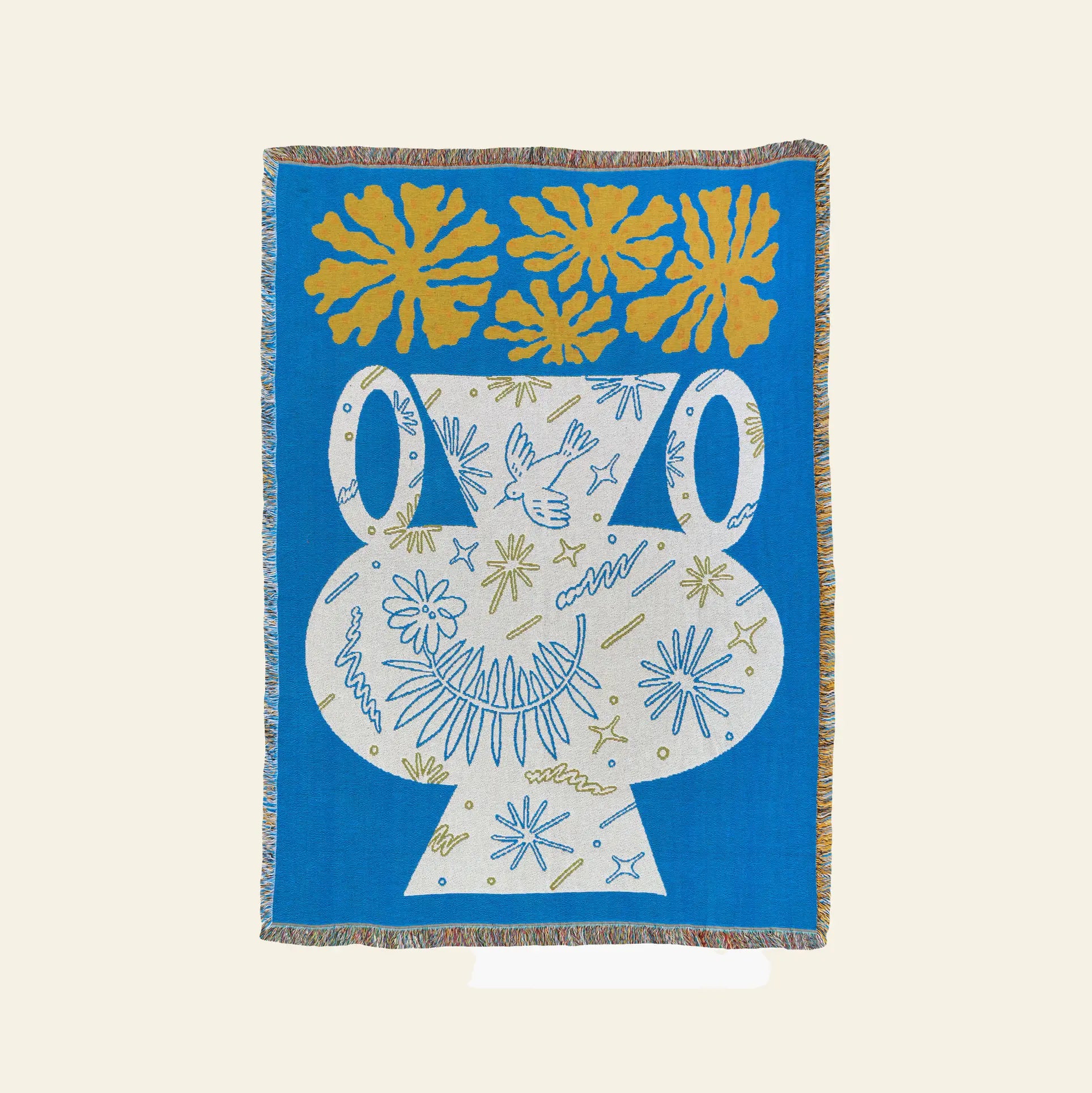 The Slowdown Studio Hudson Throw by Slowdown Studio is a woven blanket made from recycled cotton, featuring a large white vase with abstract blue and yellow designs, three yellow leafy shapes, a solid blue background, and decorative fringe.