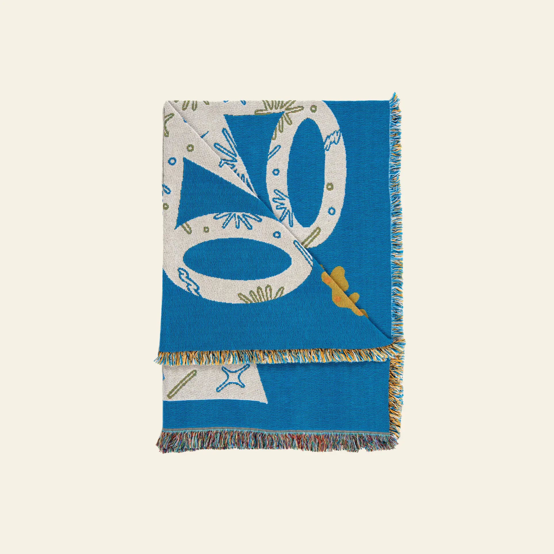 The Slowdown Studio Hudson Throw by Slowdown Studio is a folded blue woven throw made from sustainable recycled cotton, featuring a multicolor abstract pattern with large cream shapes, green accents, mustard detail, and a fringe edge.