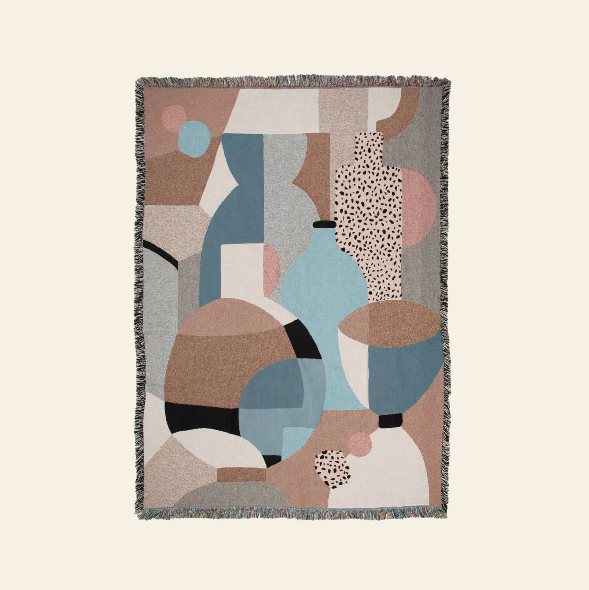 The Slowdown Studio Pollard Throw is a woven blanket made from recycled cotton, showcasing abstract overlapping geometric shapes and vases in muted tones, and finished with a textured fringe border.