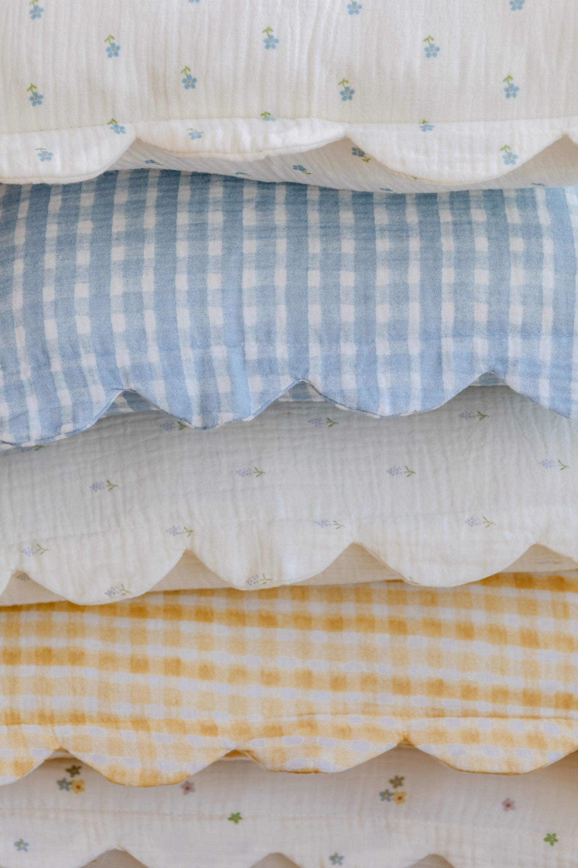 The Soft Spot Soft Petal Cushion Covers, Set of 2, by Soft Spot, feature scalloped edges and come in blue or yellow checks and blue-green floral prints on white, made from organic cotton.
