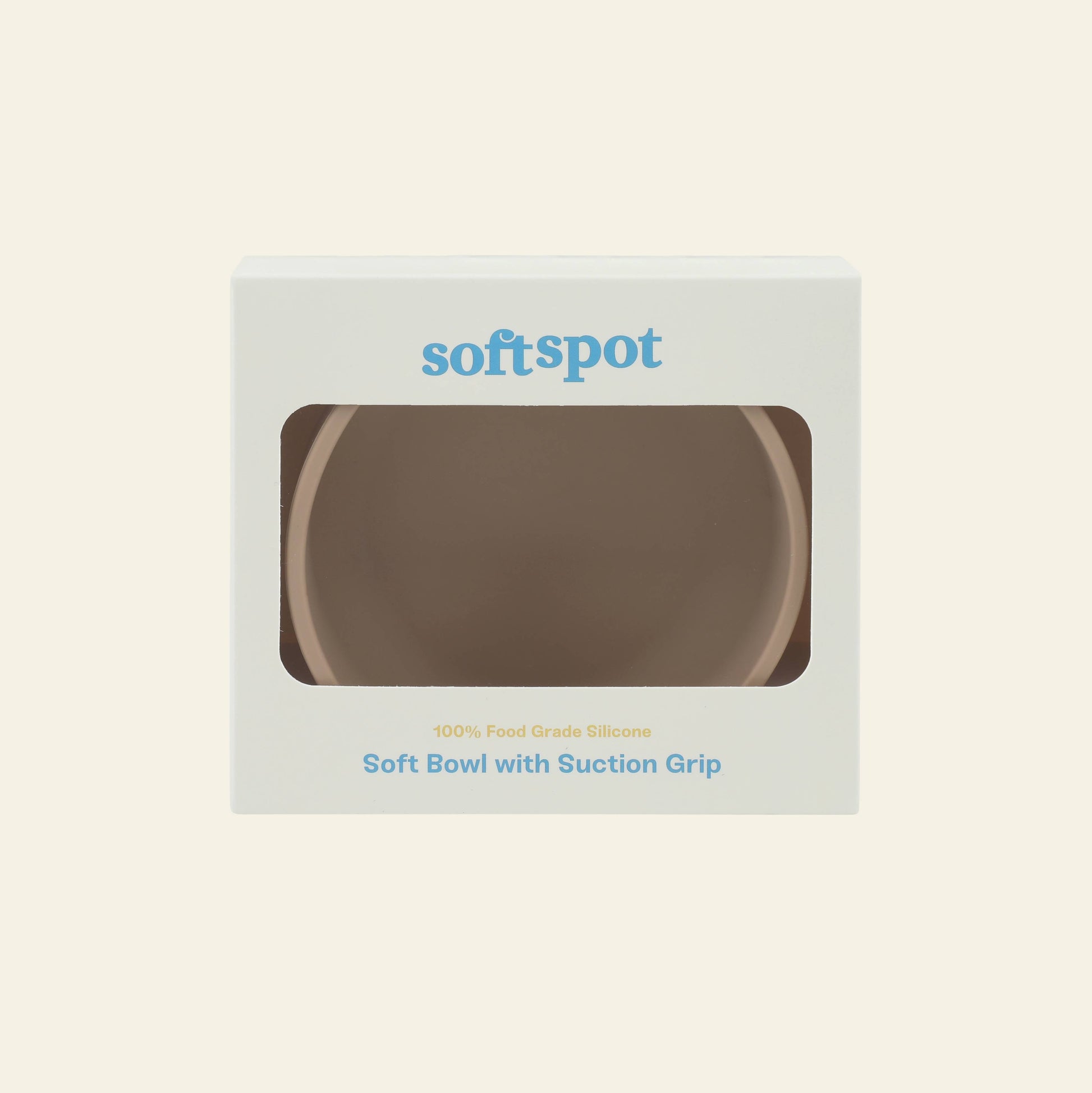 A beige food-grade silicone Soft Spot Soft Suction Bowl with a suction grip is displayed in white packaging with a transparent window. The box shows the Soft Spot logo and product name in blue and gold text.