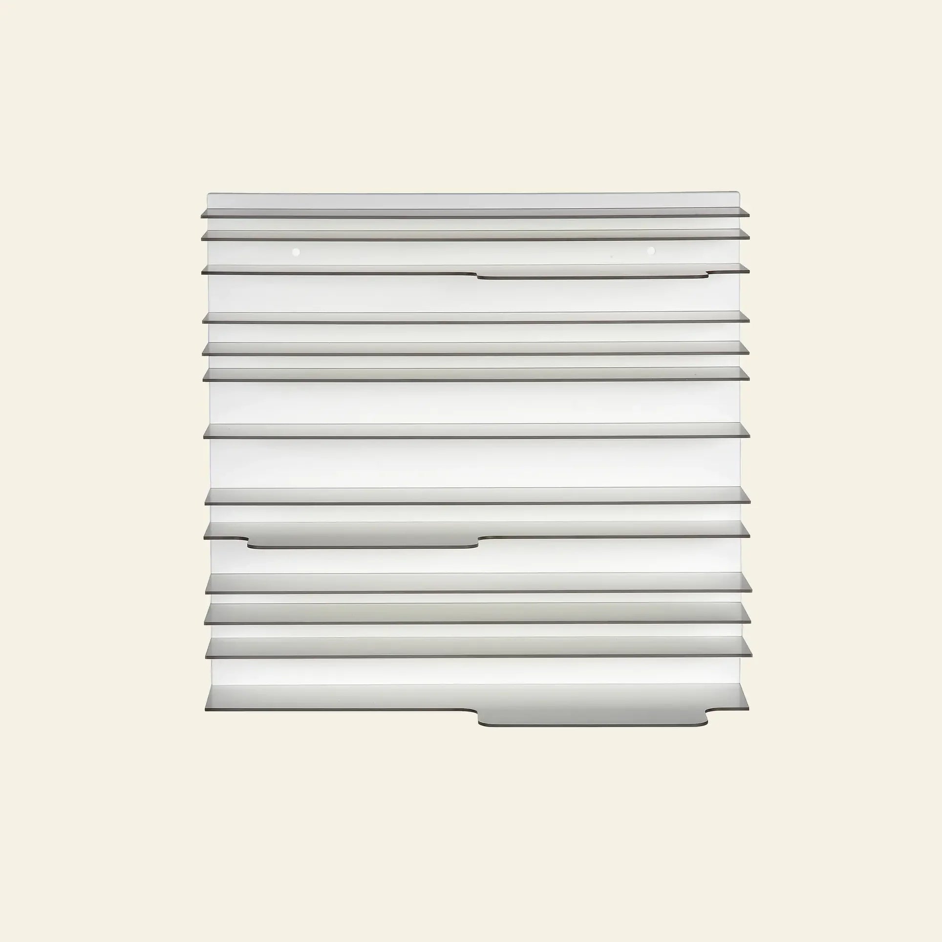 The Spectrum Paperback Wallsystem 60x60 by Spectrum features a minimalist rectangular vent cover with horizontal slats and two screw holes, designed to complement any modern wall system. Photographed against an off-white background.