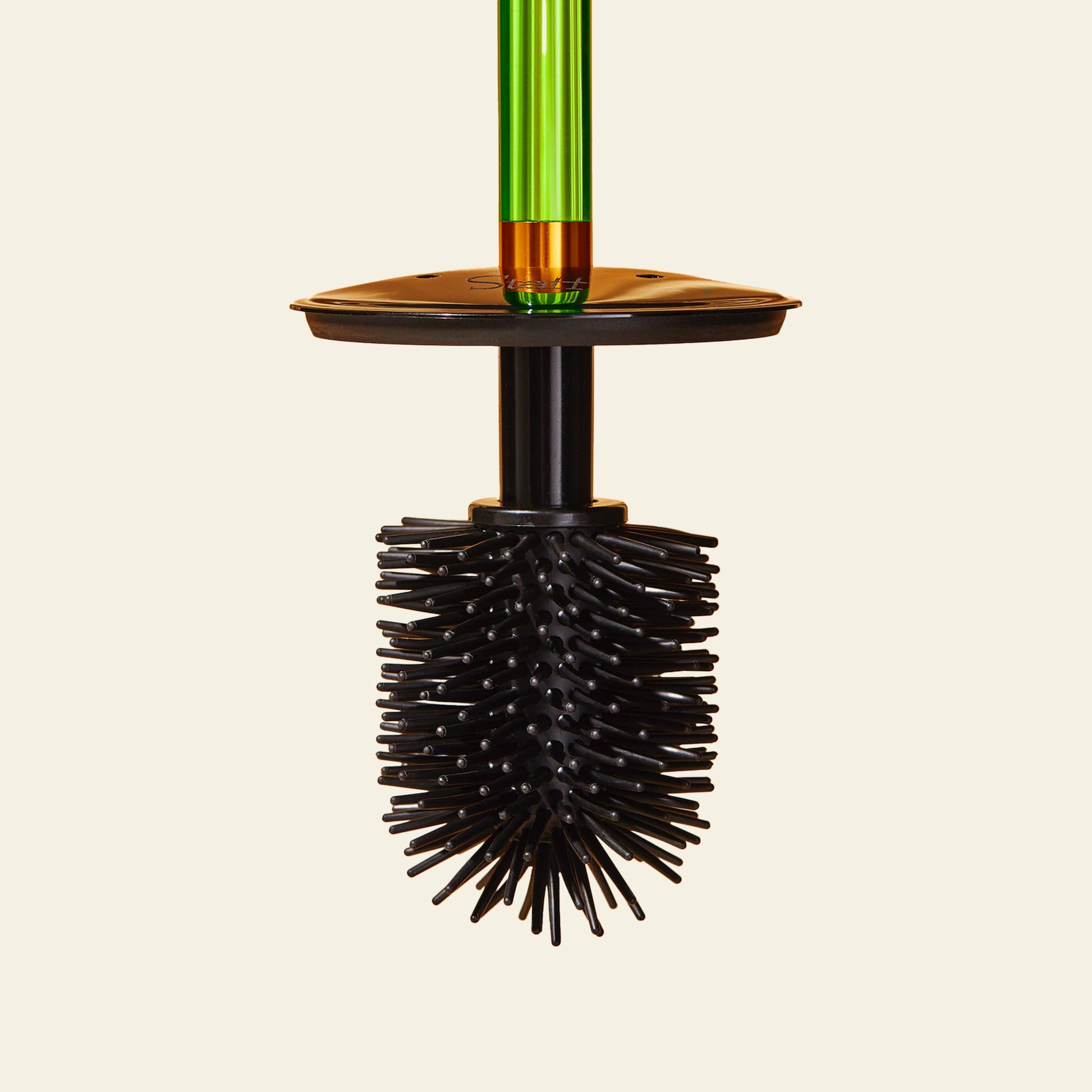 The Staff The Toilet Brush - Green by Staff, with a black silicone brush and flexible bristles, a green acrylic handle, and a replaceable head, is displayed upright against a plain beige background.