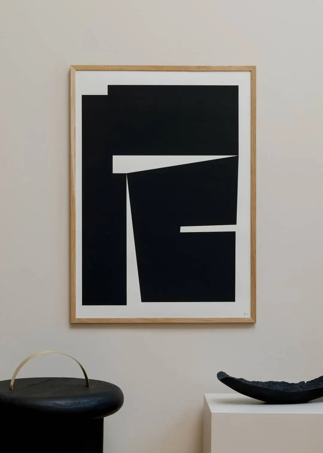 The Poster Clubs Madelen Möllard - Flowers in Blue Vase (50x70) art print hangs on a light wall above a black round object and wavy bowl atop white furniture, adding abstract style to the space.