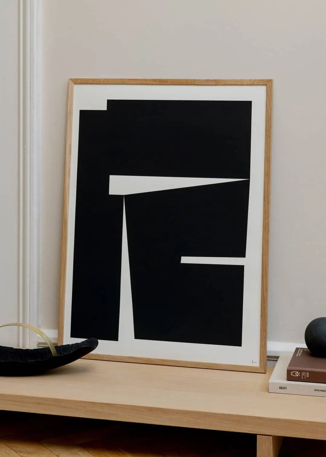 The Poster Club Madelen Möllard - Flowers in Blue Vase (50x70) art print is displayed on a light wooden surface against a beige wall, accompanied by decorative objects.