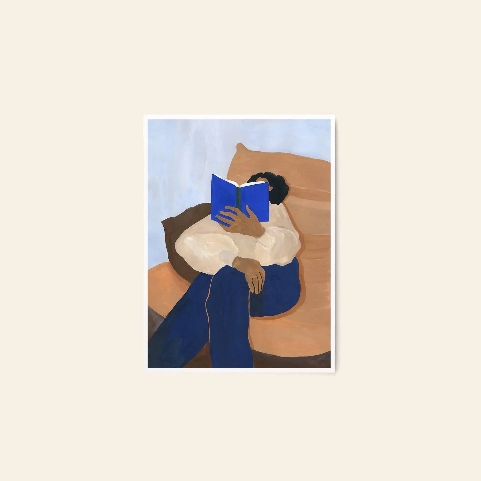 The Poster Club Anna Johansson - Monday (30x40): Art print of a person on a brown chair, in a white shirt and blue pants, reading a blue book. Light neutral background. From The Poster Club.