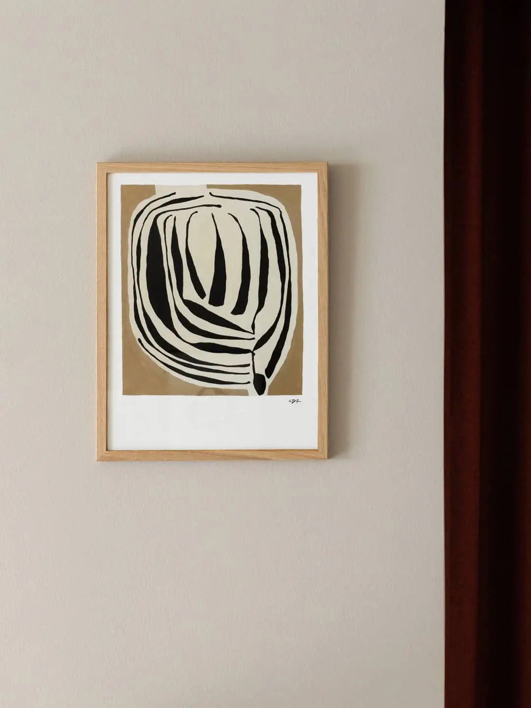 The Poster Club Berit Mogensen Lopez - Improvise (50x70) art print features black and beige curved lines on a light background, shown framed on a light wall beside a dark brown curtain.