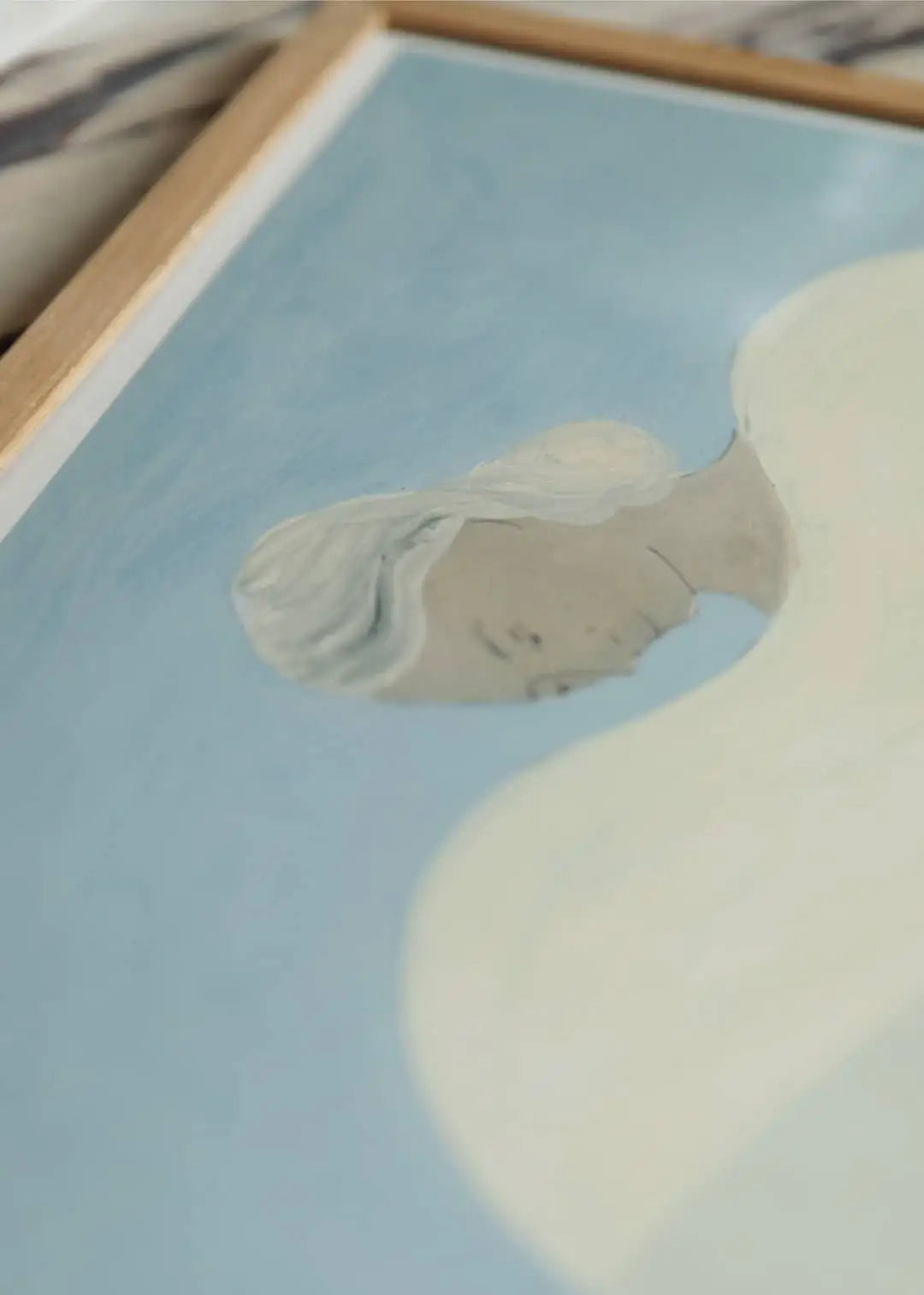 A minimalist figure with pale skin and white hair is depicted against a soft blue backdrop in the Improvise (50x70) art print by Berit Mogensen Lopez for The Poster Club, framed elegantly in wood with gentle curves and subtle details.