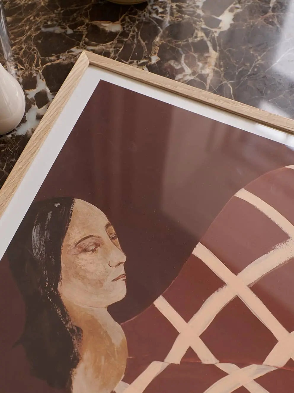 The Poster Club Berit Mogensen Lopez - Improvise (50x70) framed abstract art print features a womans face with closed eyes and long dark hair, set against a brown background with beige geometric lines. Available at The Poster Club.