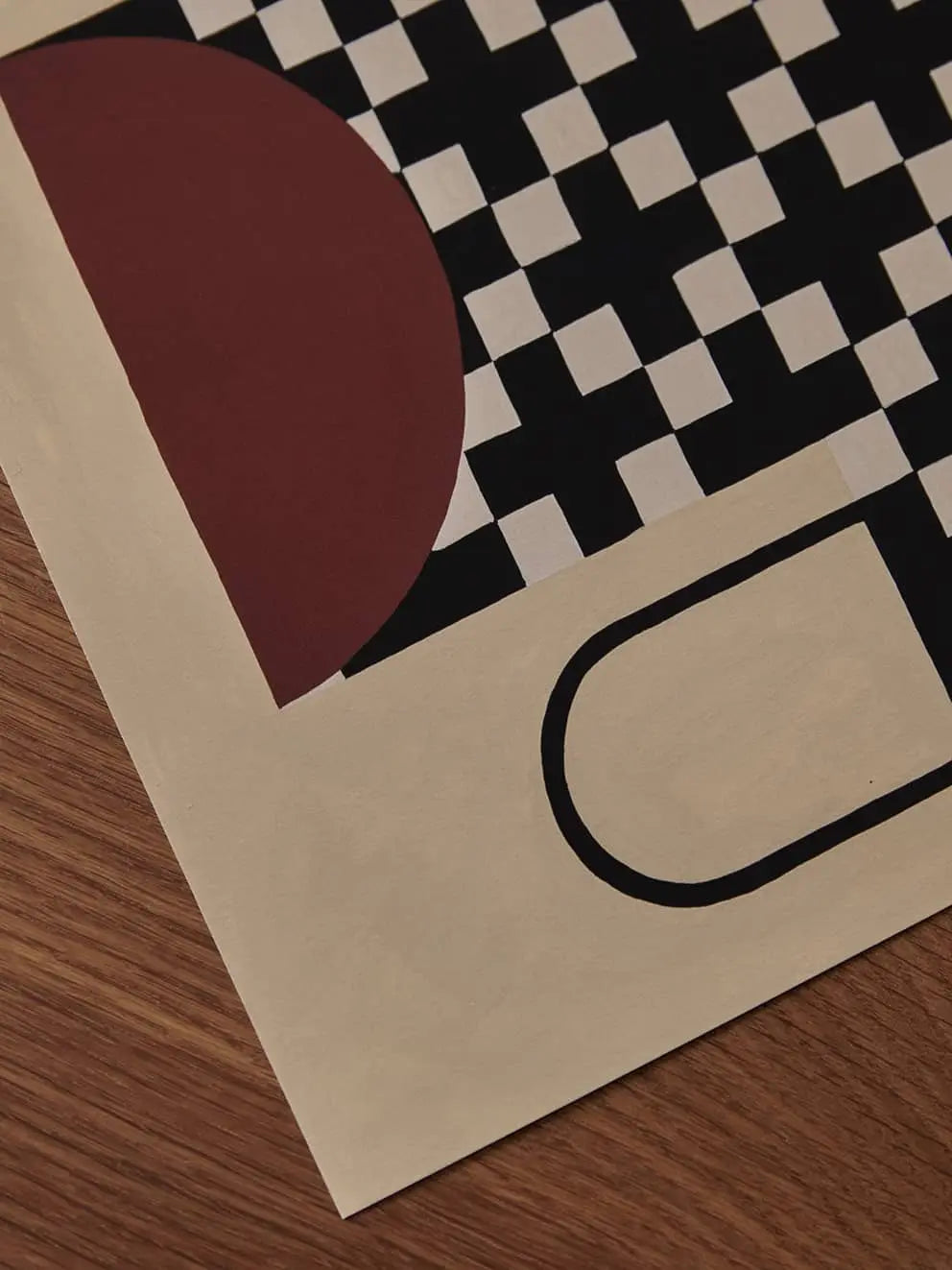 A close-up of The Poster Club Studio Paradissi - Vase With Cross Pattern (50x70) fine art giclée print by The Poster Club, featuring geometric shapes on premium art paper, displayed atop a wooden surface.