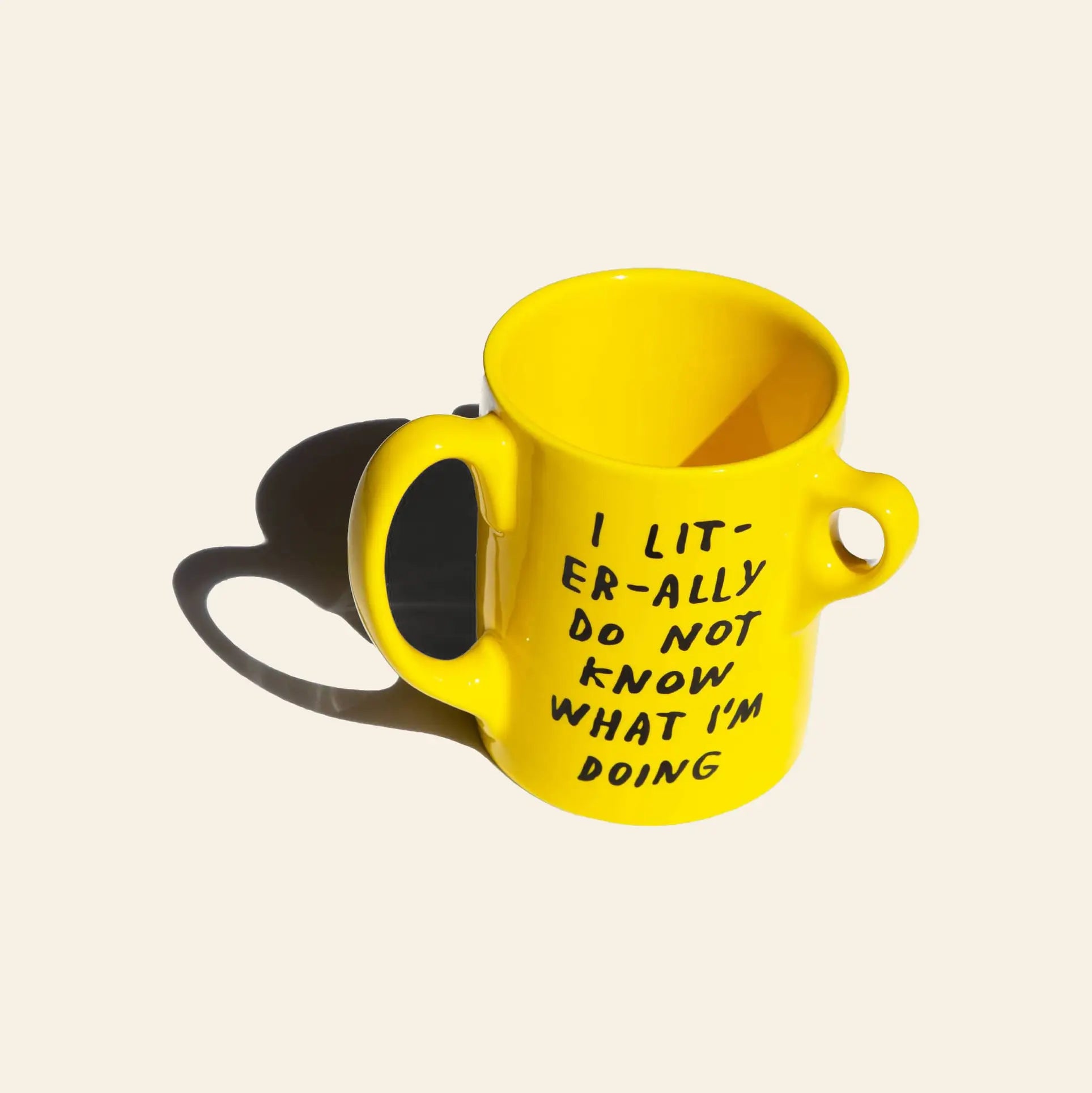 The Third Drawer Down Adam JK - I Literally Do Not Know Mug is a bright yellow mug with two handles and a small loop, featuring bold black text stating, I LIT-ER-ALLY DO NOT KNOW WHAT IM DOING.