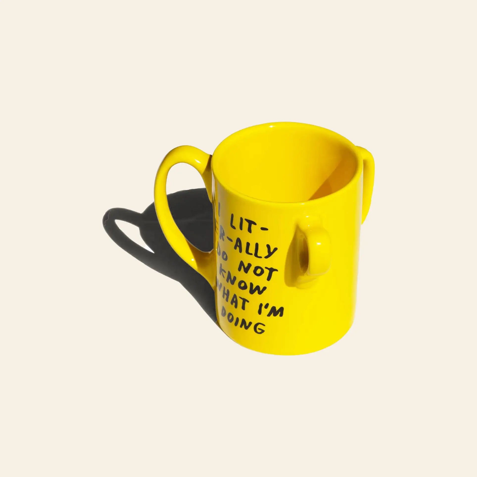 The Third Drawer Down Adam JK - I Literally Do Not Know Mug is a bright yellow two-handled mug featuring black handwritten text, shown on a plain light background with its shadow visible.