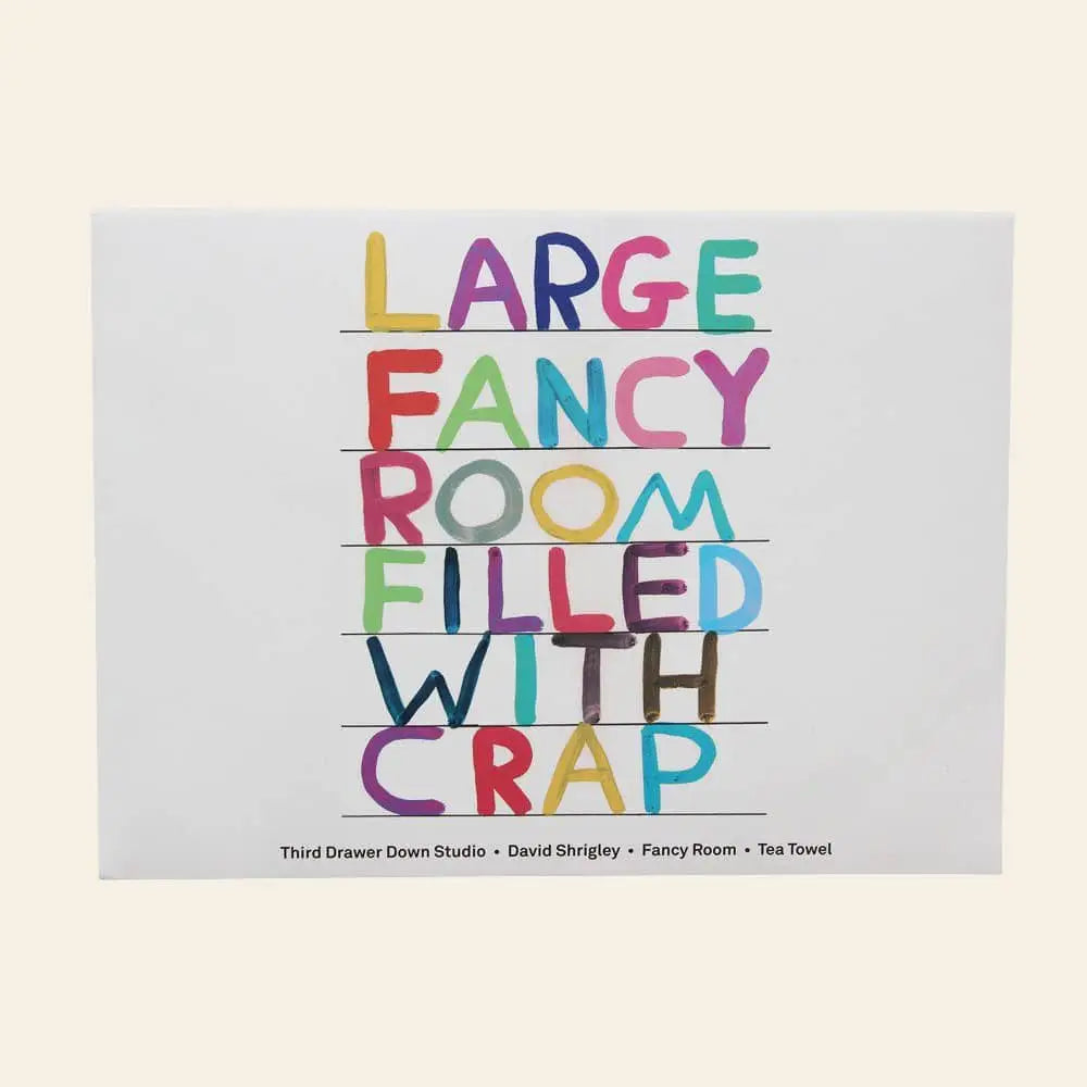 The Third Drawer Down David Shrigley - Fancy Room Tea Towel features bold, multicolored text reading “LARGE FANCY ROOM FILLED WITH CRAP.” A quirky, unique kitchen decor piece—perfect as a fun gift.