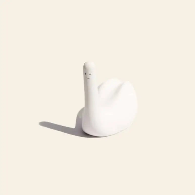 The Third Drawer Down David Shrigley Ridiculous Stress Swan-Thing is a minimalist white ceramic swan with a simple face, casting a soft shadow—an ideal stress-free gift from Third Drawer Down.