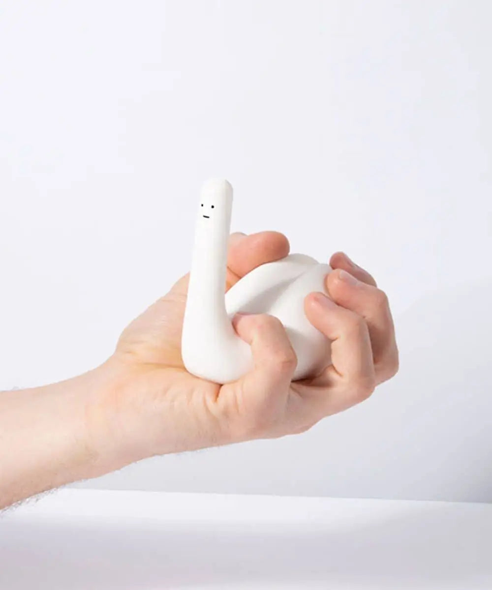 A hand holds the Third Drawer Down David Shrigley - Ridiculous Stress Swan-Thing, a quirky white inflatable swan stress toy with a simple face, set against a plain white background—a fun gift for any occasion.