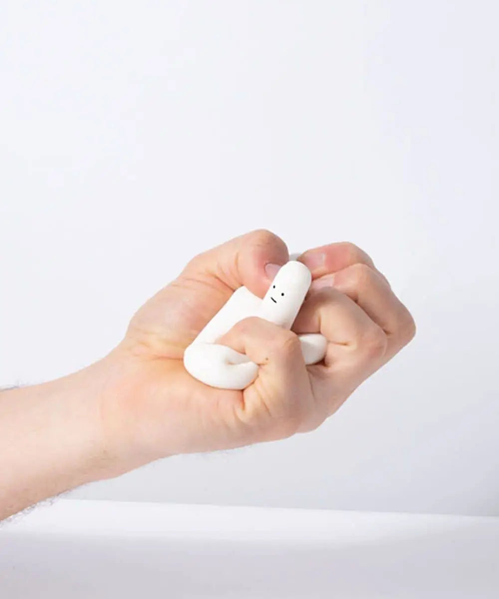 A hand squeezes the Third Drawer Down David Shrigley - Ridiculous Stress Swan-Thing, a quirky white stress toy by Third Drawer Down, with a simple face—an ideal playful gift set against a plain light background.