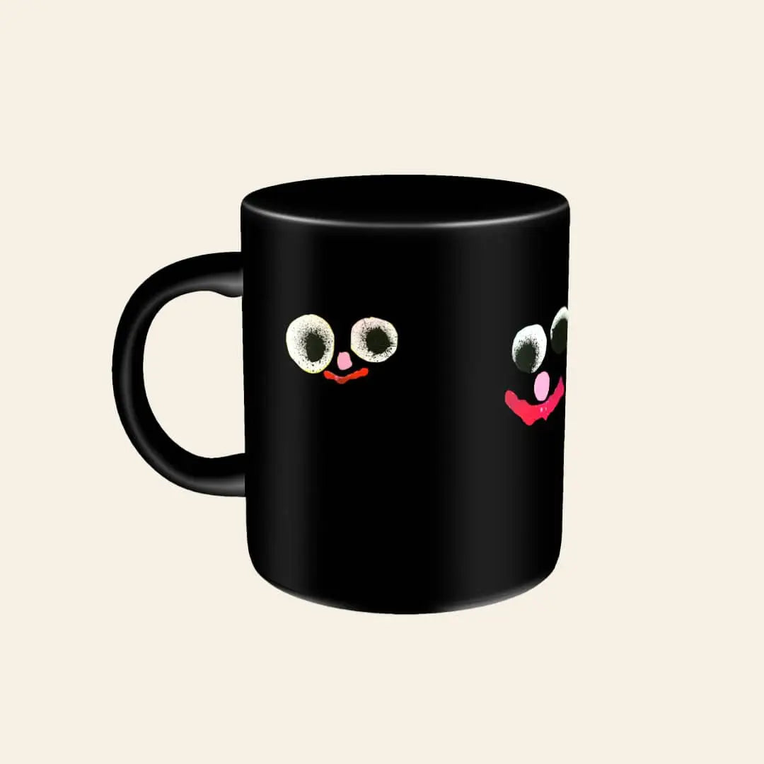 The Third Drawer Down Jon Burgerman Fuzzy Friend Mug, featuring a whimsical face with large googly eyes and a pink smiling mouth, sits on a light beige background.