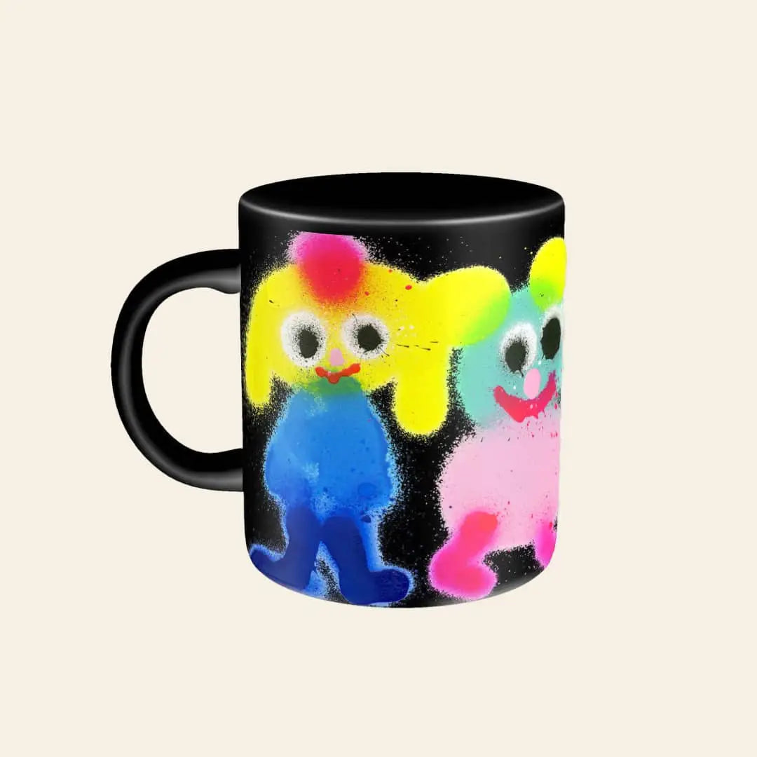 The Third Drawer Down Jon Burgerman - Fuzzy Friend Mug features two vibrant cartoon creatures with big eyes, colorful hair, and blue and pink bodies on a black mug. Brand: Third Drawer Down.