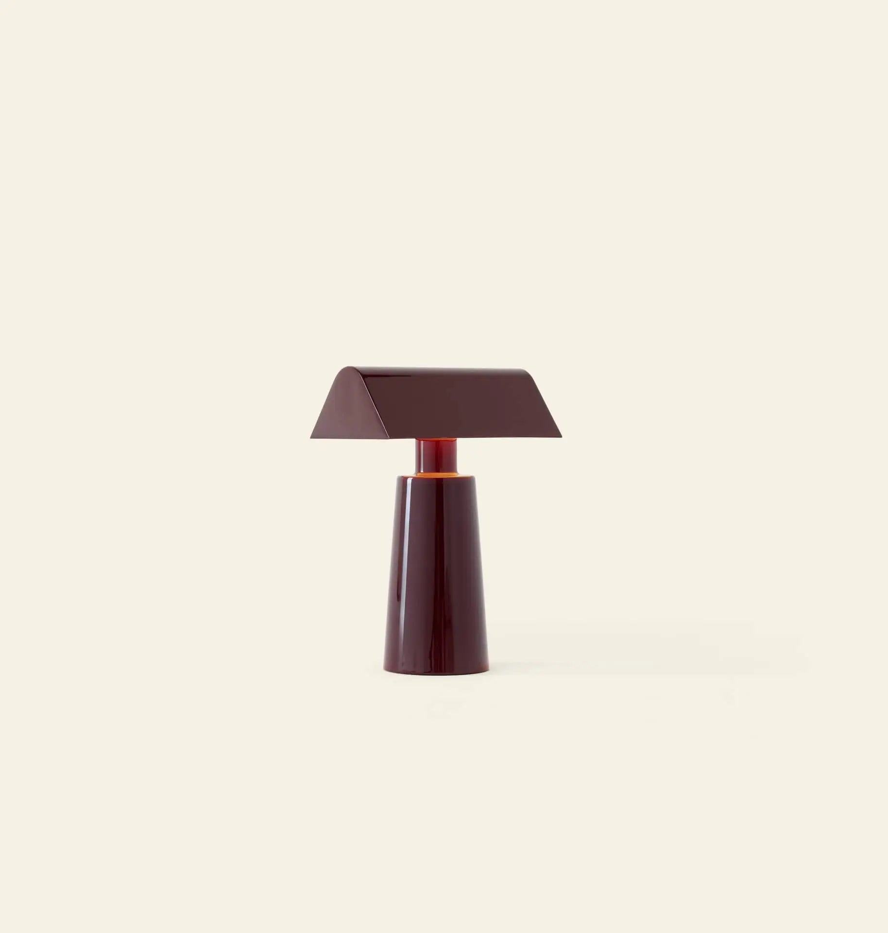 The &Tradition Caret MF1 Portable Table Lamp features a modern, dark burgundy conical base and flat, slanted rectangular shade, echoing classic banker’s lamps, shown against a plain off-white background.