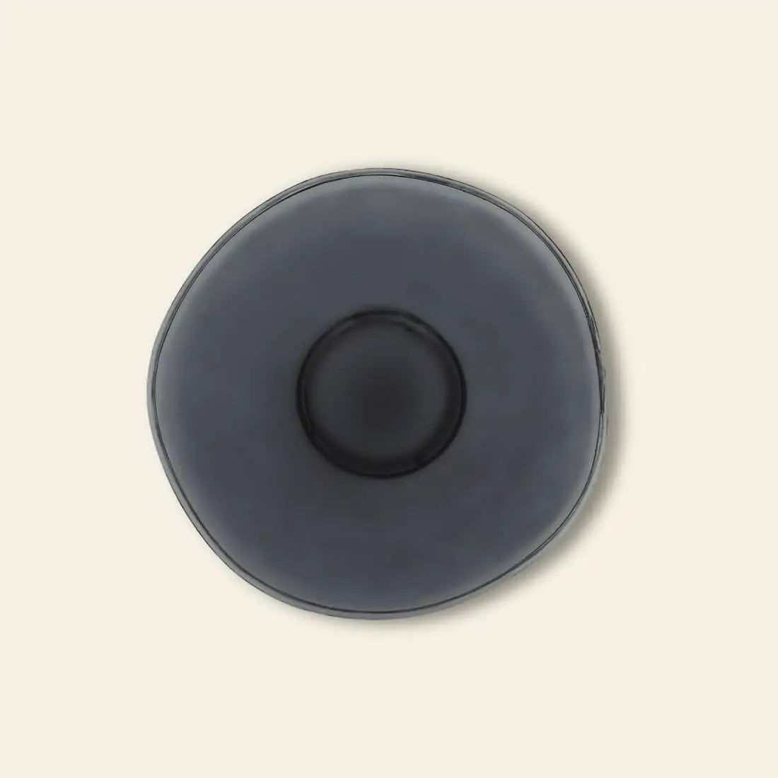 The Urban Nature Culture Breakfast Plate Recycled Glass by Urban Nature Culture is a round, dark gray plate with a slightly irregular shape and raised center—an eco-friendly, stylish addition to sustainable living.