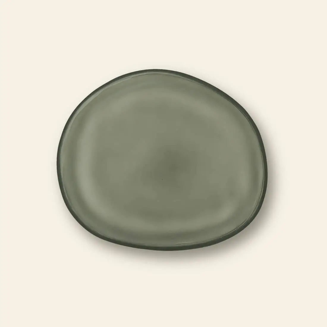 The Urban Nature Culture Plate Recycled Glass Frost by Urban Nature Culture is centered on a plain beige background, its irregular shape and frosted finish highlighting earthy tones that accentuate its natural beauty.