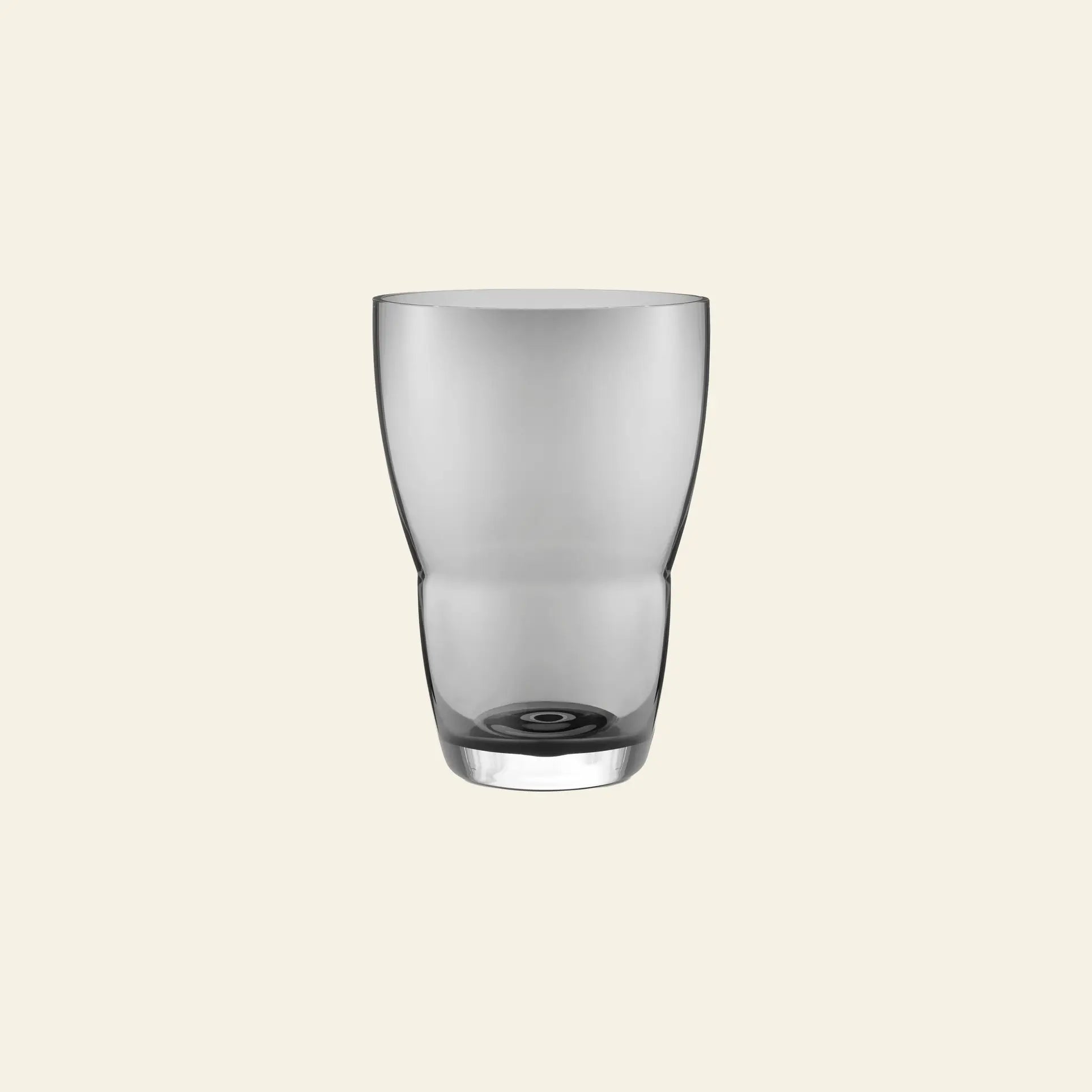 The Vipp Vipp248 Vase by Vipp, featuring a slightly curved clear glass design, is centered on a plain, light beige background, evoking minimalist decorative style.
