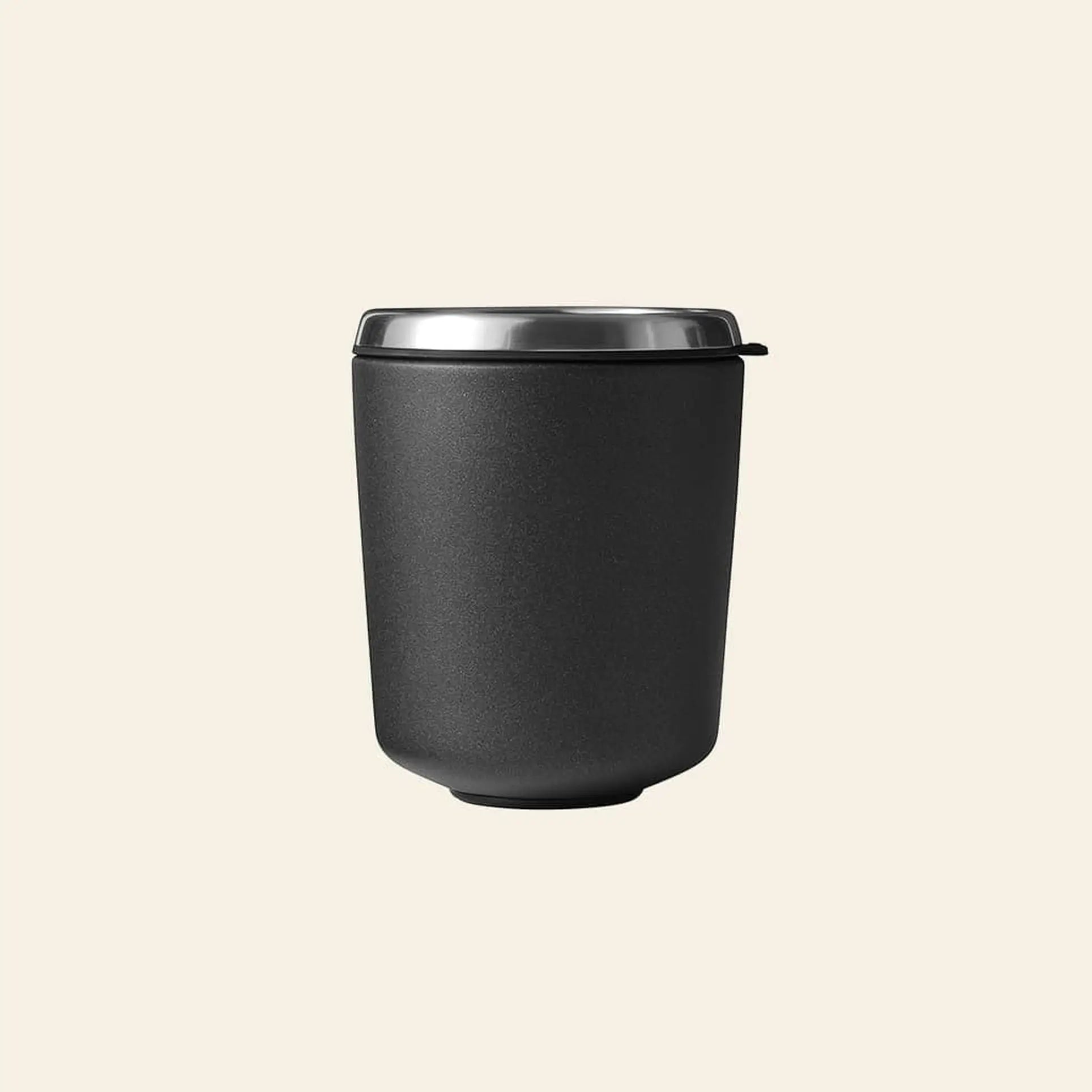 The Vipp Vipp7 Toothbrush Holder by Vipp, shown on a plain beige background, features a matte black finish with a stainless steel rim—a bathroom essential as versatile as an insulated travel mug.
