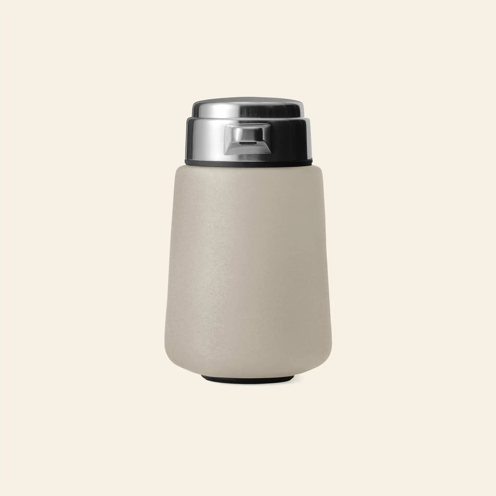 The Vipp Vipp9 Dispenser by Vipp, featuring a modern matte beige finish and silver metallic lid, stands upright against an off-white background—its sleek minimalist design echoes the iconic Vipp aesthetic.