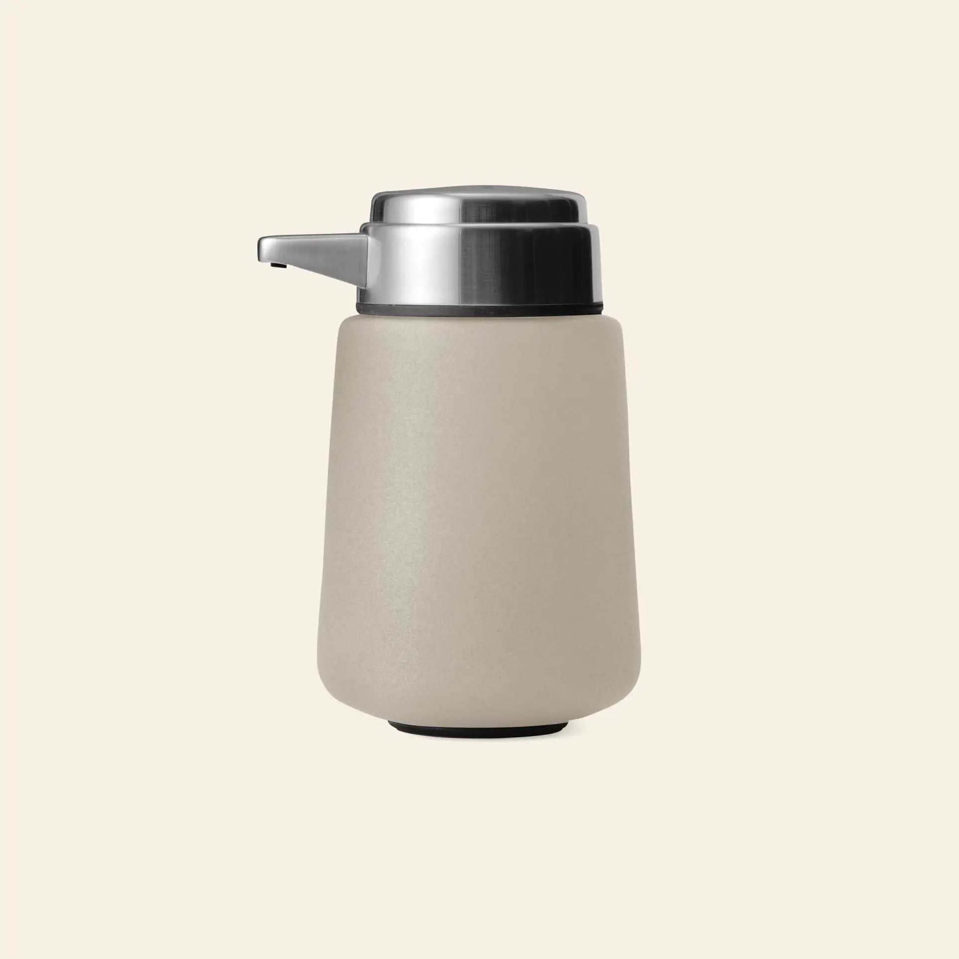 The Vipp Vipp9 Dispenser by Vipp features a matte beige body and stainless steel pump, making it a stylish accessory for contemporary kitchens. It sits on a plain, light background, blending modern design with everyday functionality.