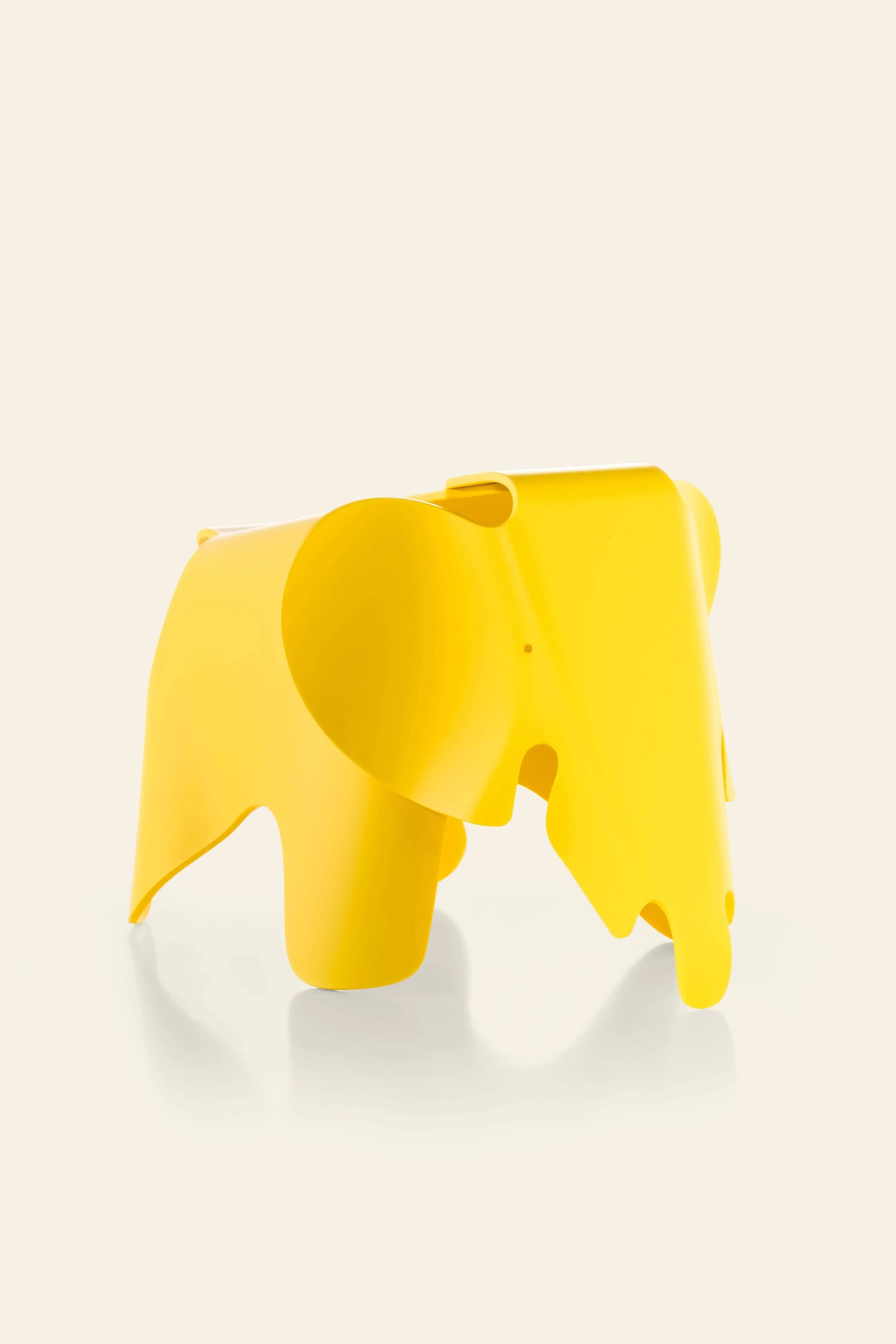 The Vitra Eames Elephant, Small by Vitra is a bright yellow, smooth plastic decorative piece with minimal details and rounded edges, featuring a playful design that enhances any space.