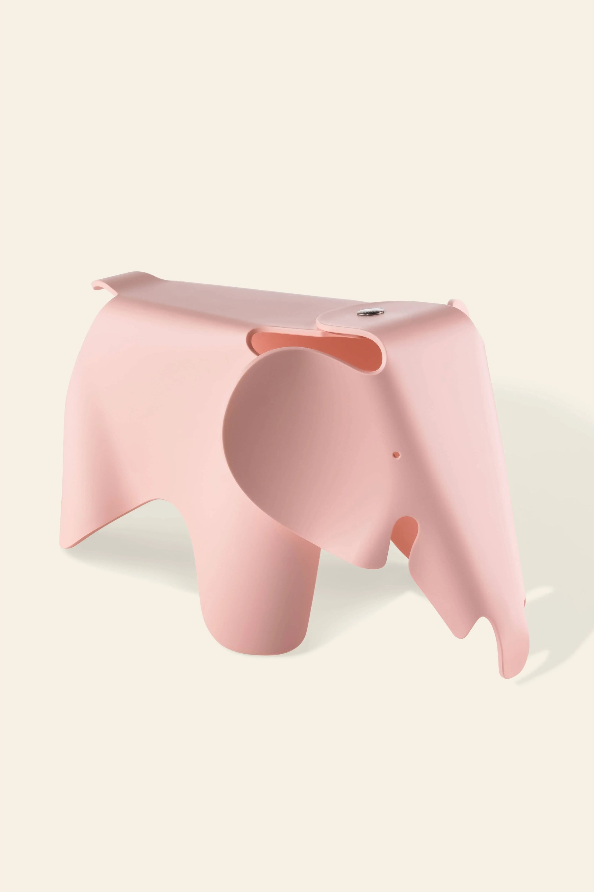 The Vitra Eames Elephant, Small by Vitra features a light pink, minimalist elephant shape with smooth, rounded forms, adding a decorative touch as it rests on an off-white background.
