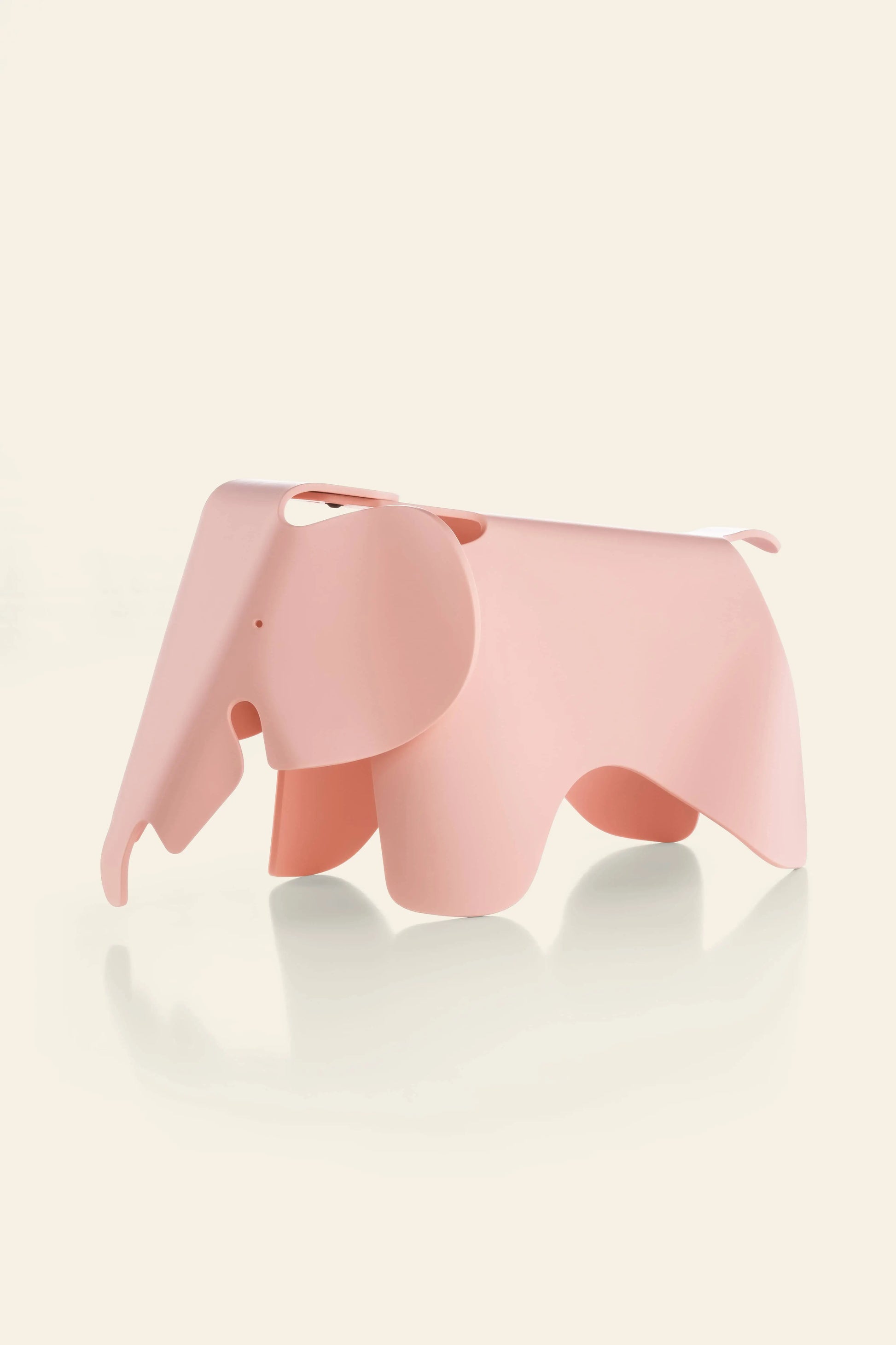 The Vitra Eames Elephant, Small by Vitra is a pink, minimalist decorative piece made from smooth plastic. Its iconic, abstract curved design adds a playful and stylish touch to any space against a light background.