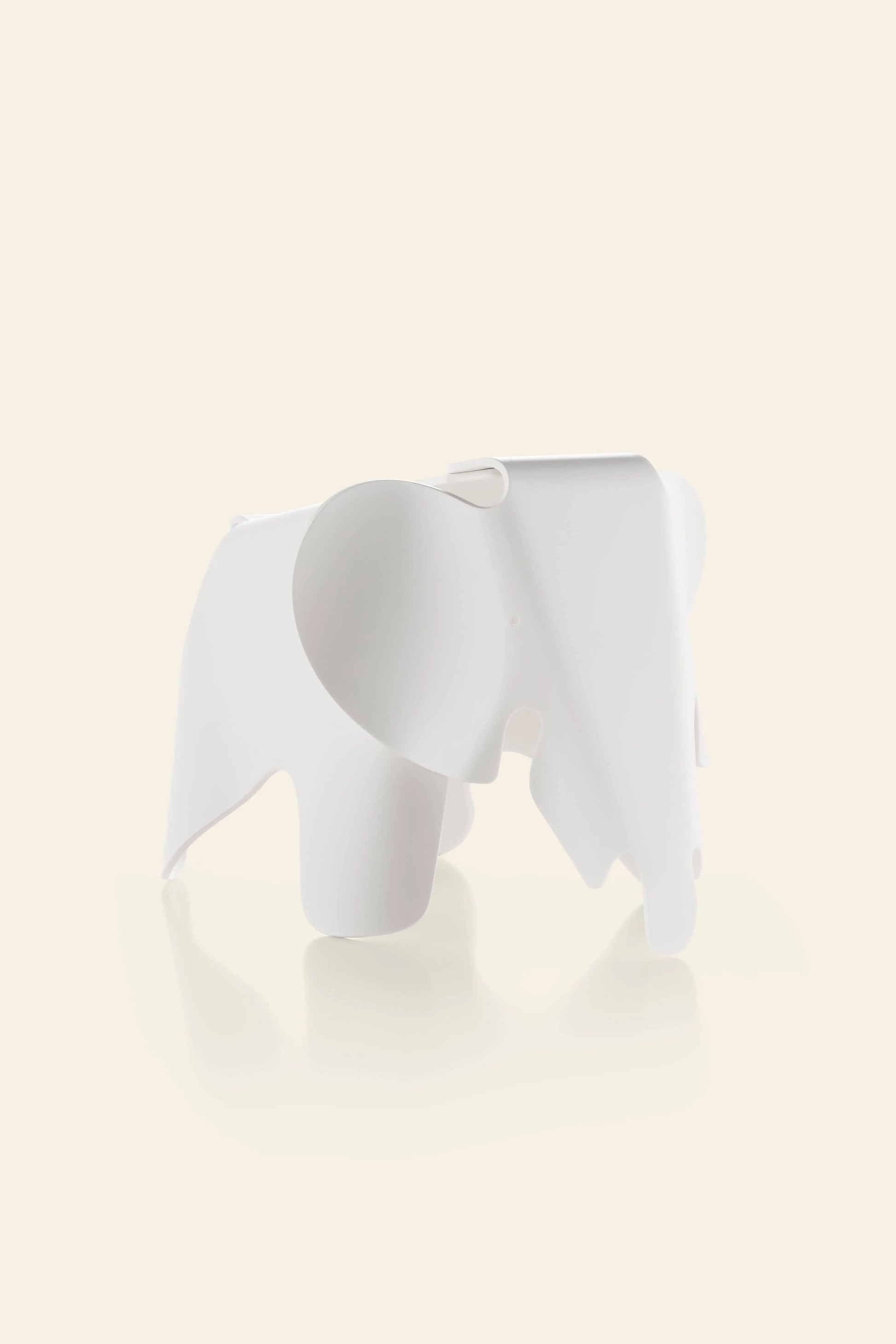 The Vitra Eames Elephant, Small by Vitra features smooth, rounded shapes and a minimalist design, adding a decorative touch against a plain, light beige background.