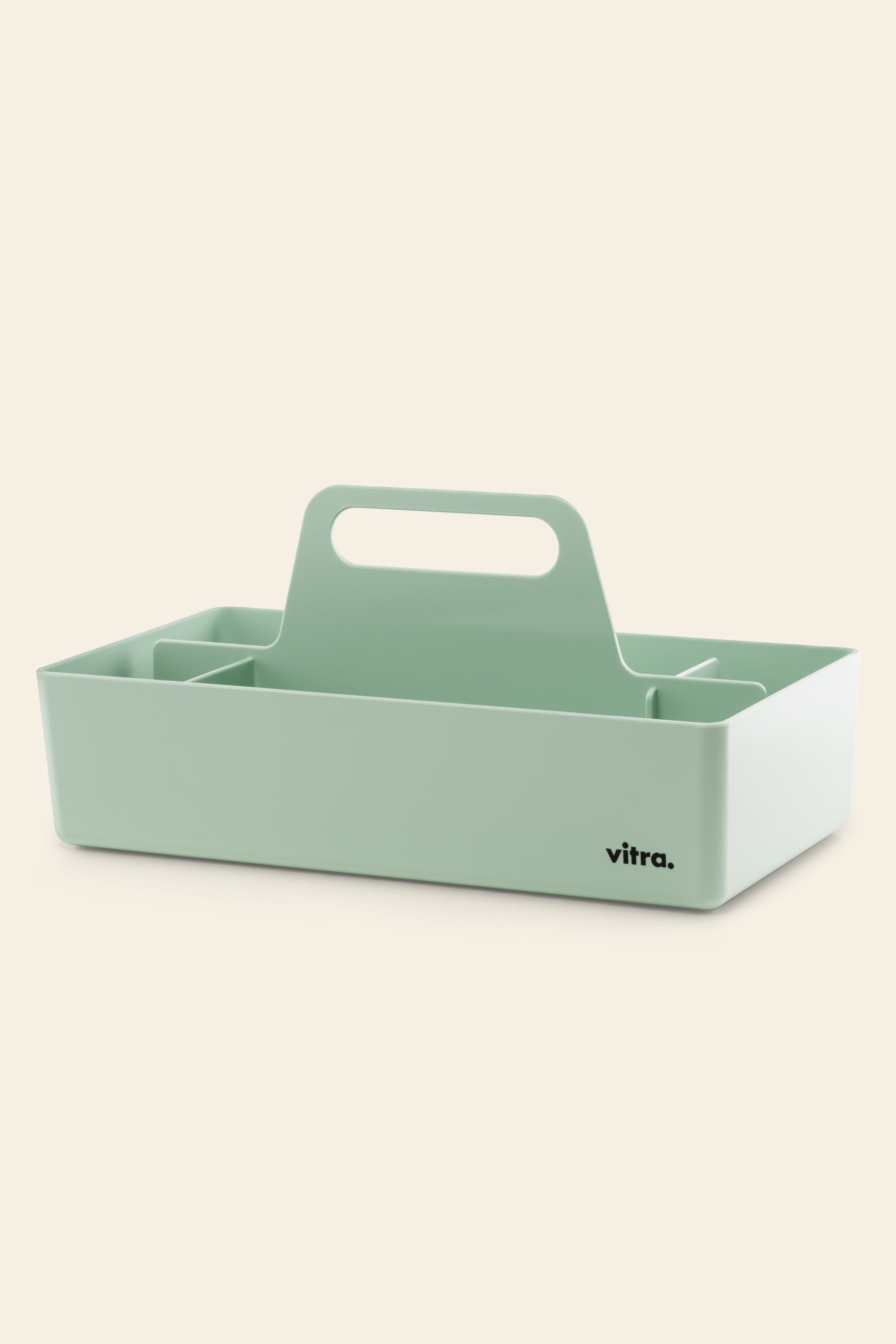 A light green Vitra Toolbox RE table caddy by Vitra, rectangular with a central handle and multiple compartments, made from recycled ABS plastic and featuring a black vitra. logo on one corner, set against a plain beige background.