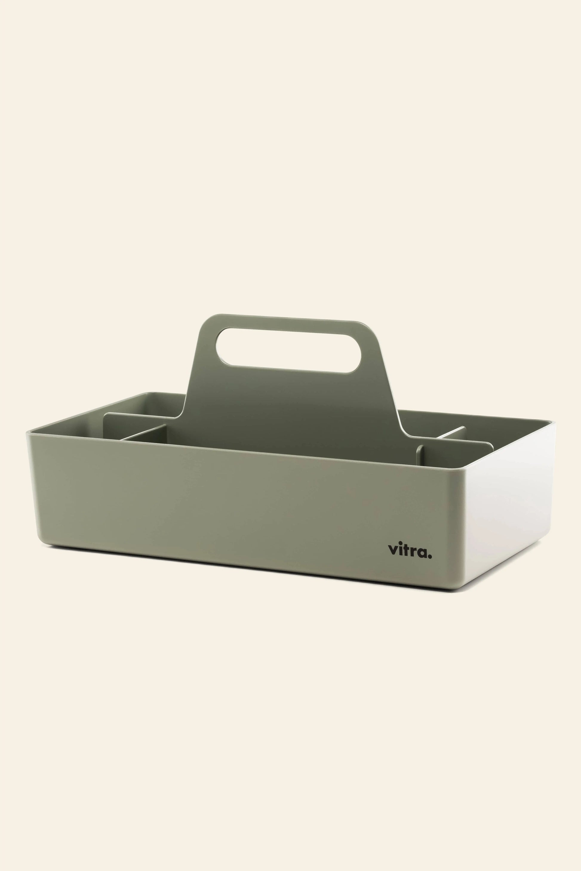 The Vitra Toolbox RE by Vitra is a rectangular, light gray storage caddy made of recycled ABS plastic with a central handle, multiple compartments, and the Vitra logo on one side, shown against a plain, light background.