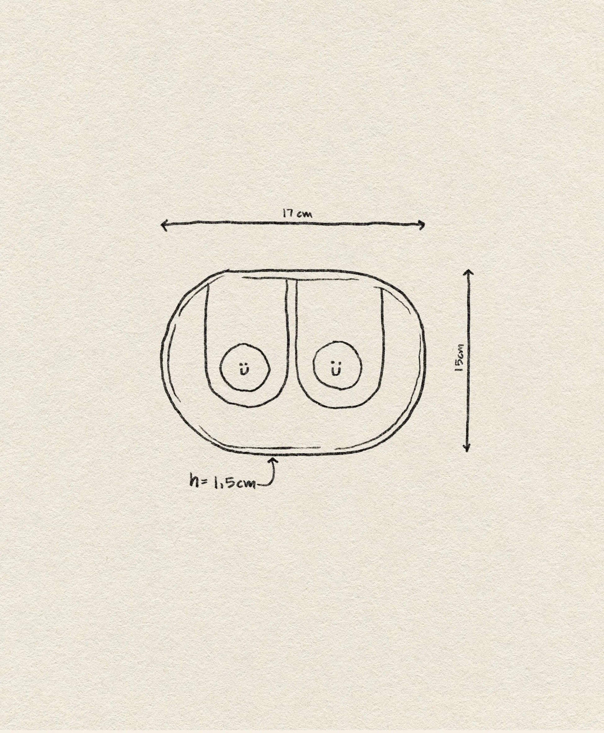 Hand-drawn sketch of two Wobbly Studio Happy Things Plate - Nénés by Wobbly Studio, side by side in an oval, each with a smiley face. Dimensions: 17cm wide, 11.5cm tall, 1.5cm high.