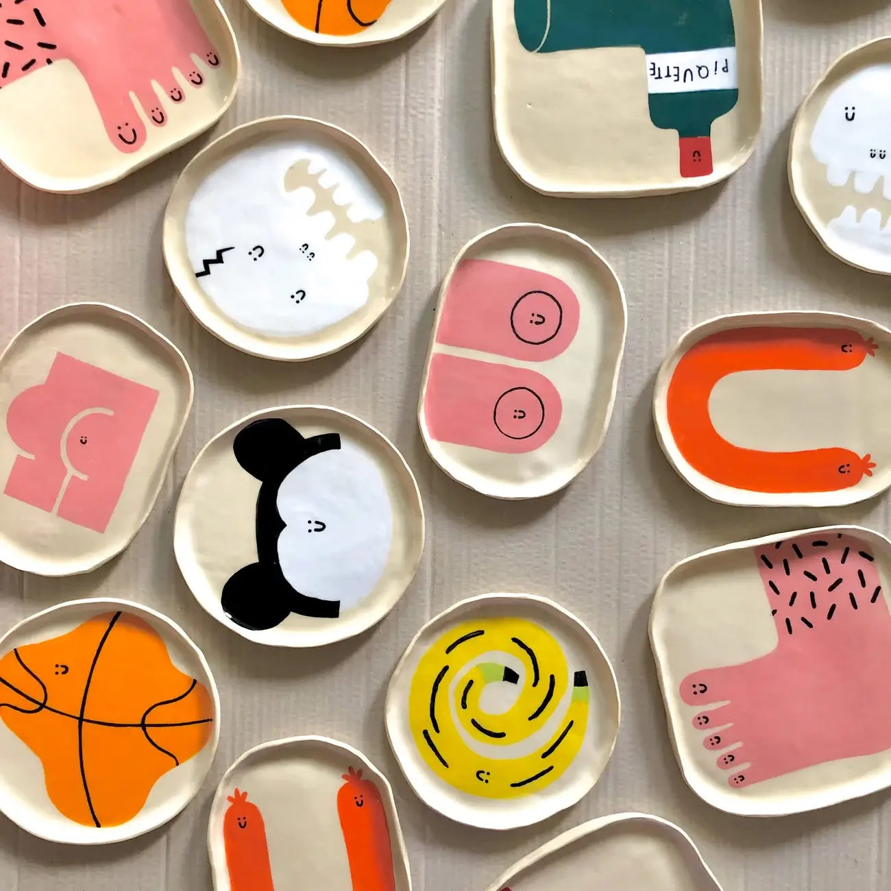 The Wobbly Studio Happy Things Plate - Souris features cheerful illustrations in vibrant colors and is displayed on a textured, light-colored surface.