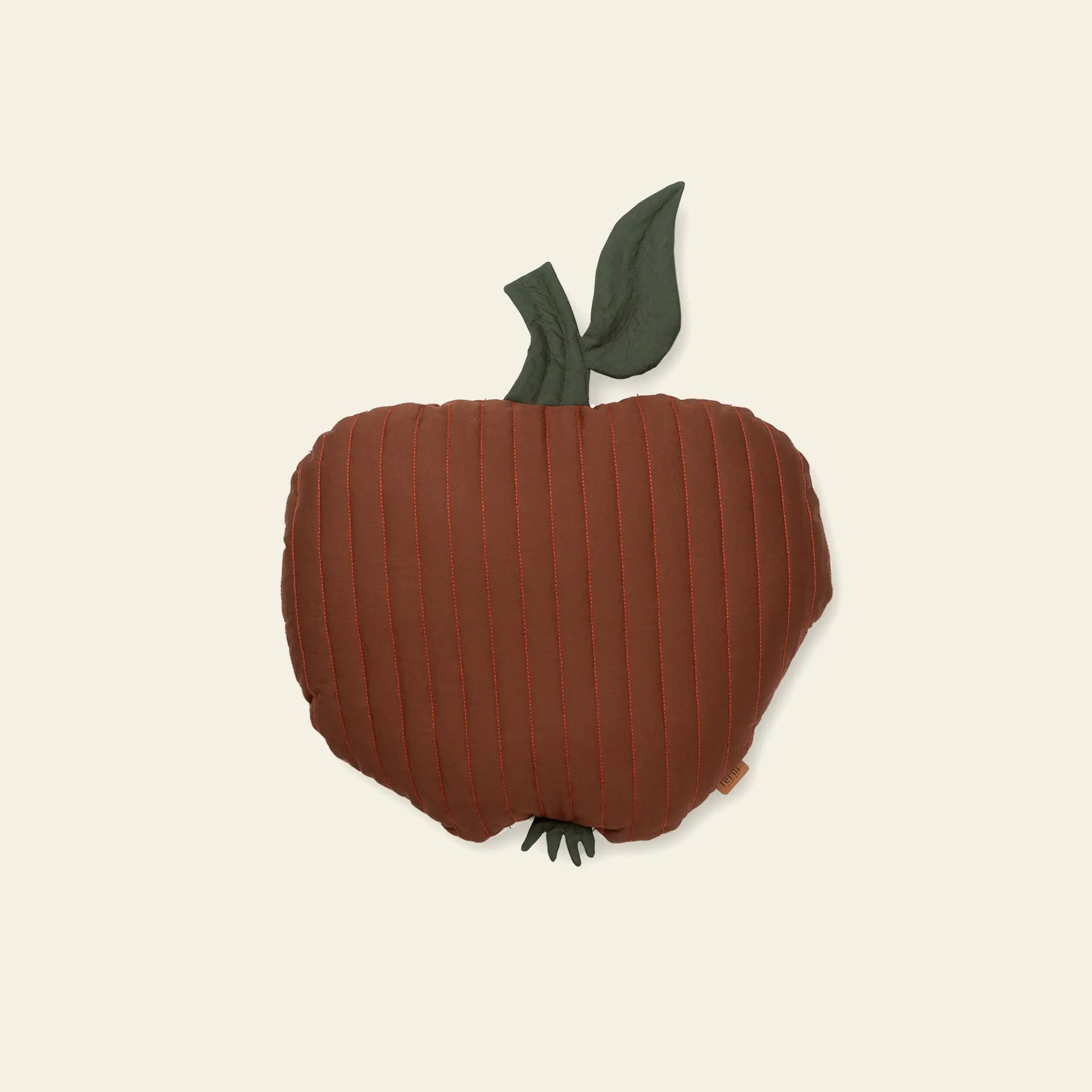 The ferm LIVING Apple Quilted Cushion is a plush, rust-red pillow shaped like an apple, made from organic quilted cotton with stitched lines and green fabric leaves—an adorable soft accent for any childs room.