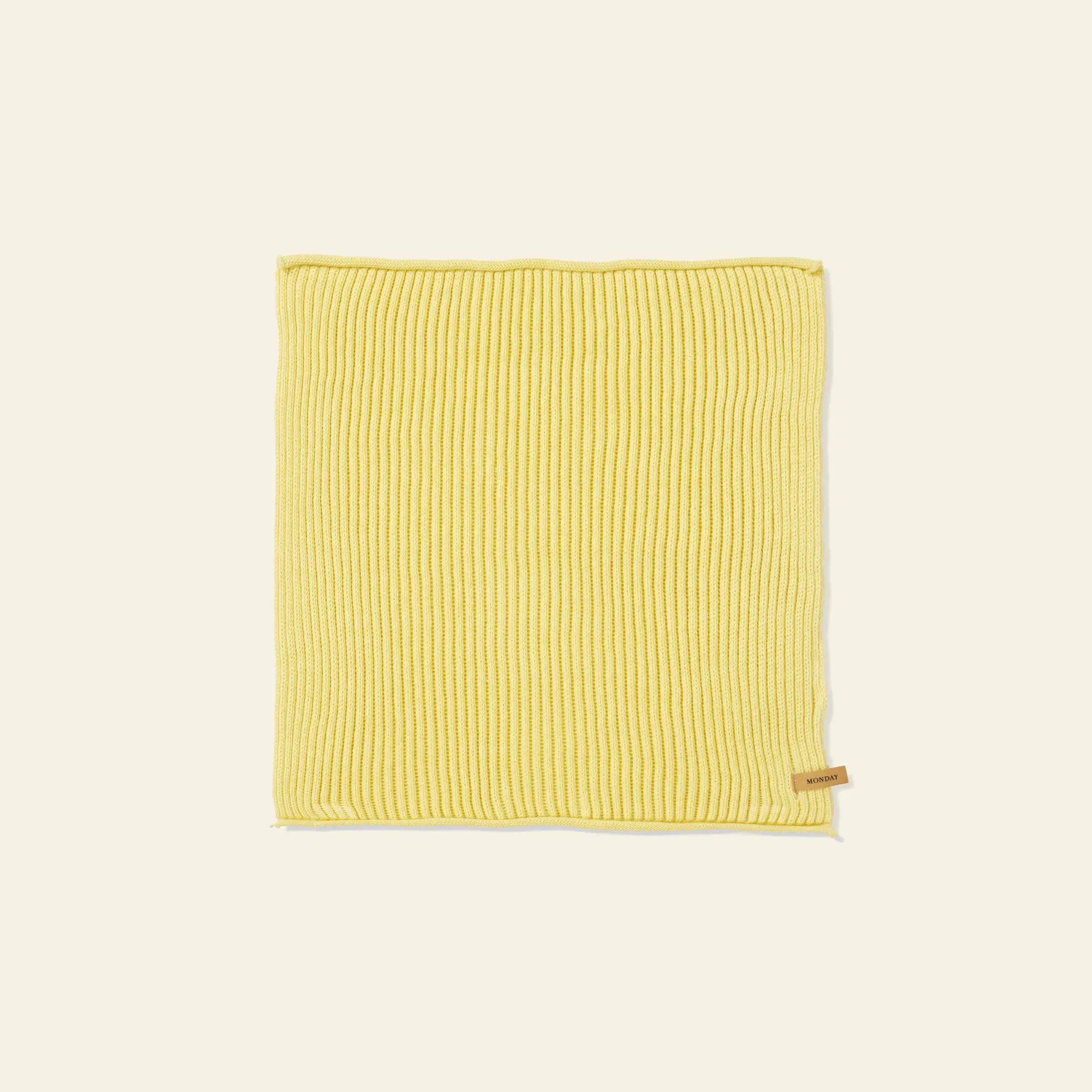 A set of 7 ferm LIVING Day Cloths, each neatly folded and rectangular, made from organic cotton in yellow ribbed knit with a small tan tag on one edge, displayed on a plain light background.