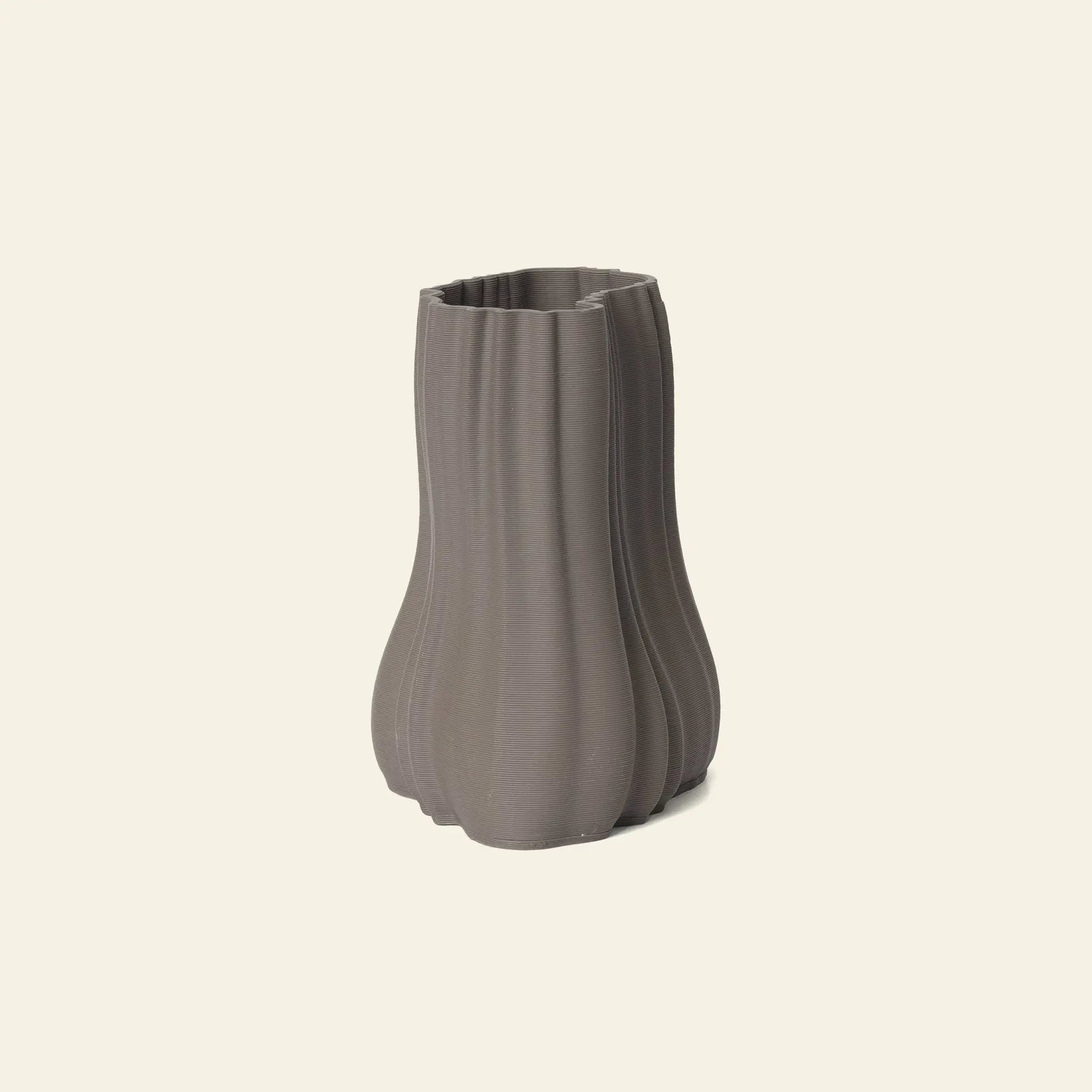 The ferm LIVING Moire Vase, Small, features a 3D-printed wavy, vertically ridged design in gray and stands on a light beige background, showcasing ferm LIVINGs modern take on clay-inspired craftsmanship.