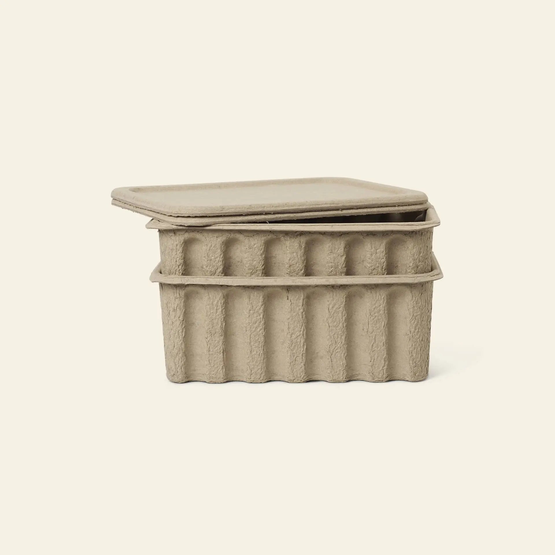 The ferm LIVING Paper Pulp Box Large, Set of 2, features rectangular lidded containers made from textured beige recycled paper—an eco-friendly storage option from ferm LIVING.