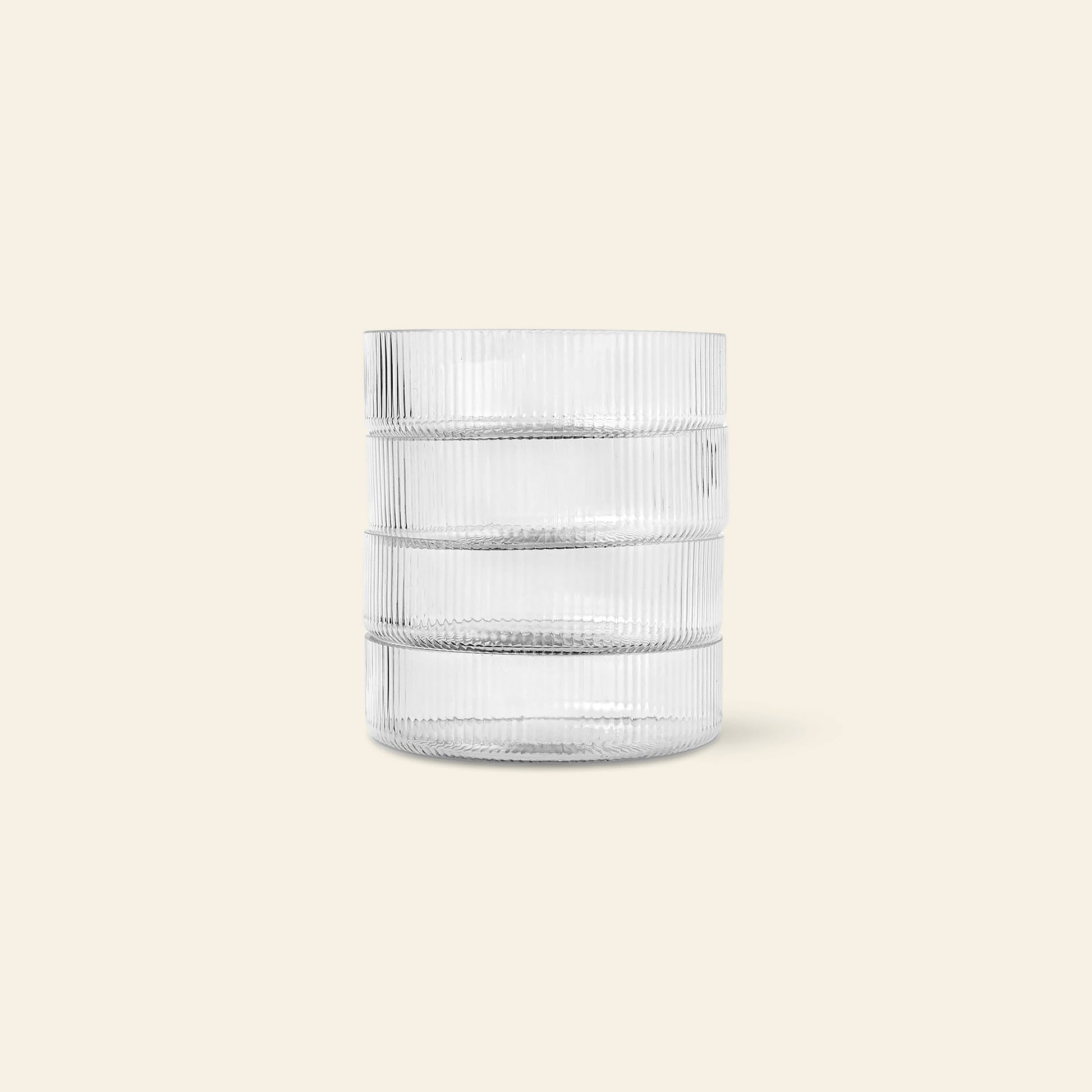 The ferm LIVING Ripple Serving Bowls, Set of 4, feature a cylindrical shape with textured horizontal ridges and vertical lines. Crafted from mouth-blown glass, these bowls are displayed upright on a plain, light beige background.